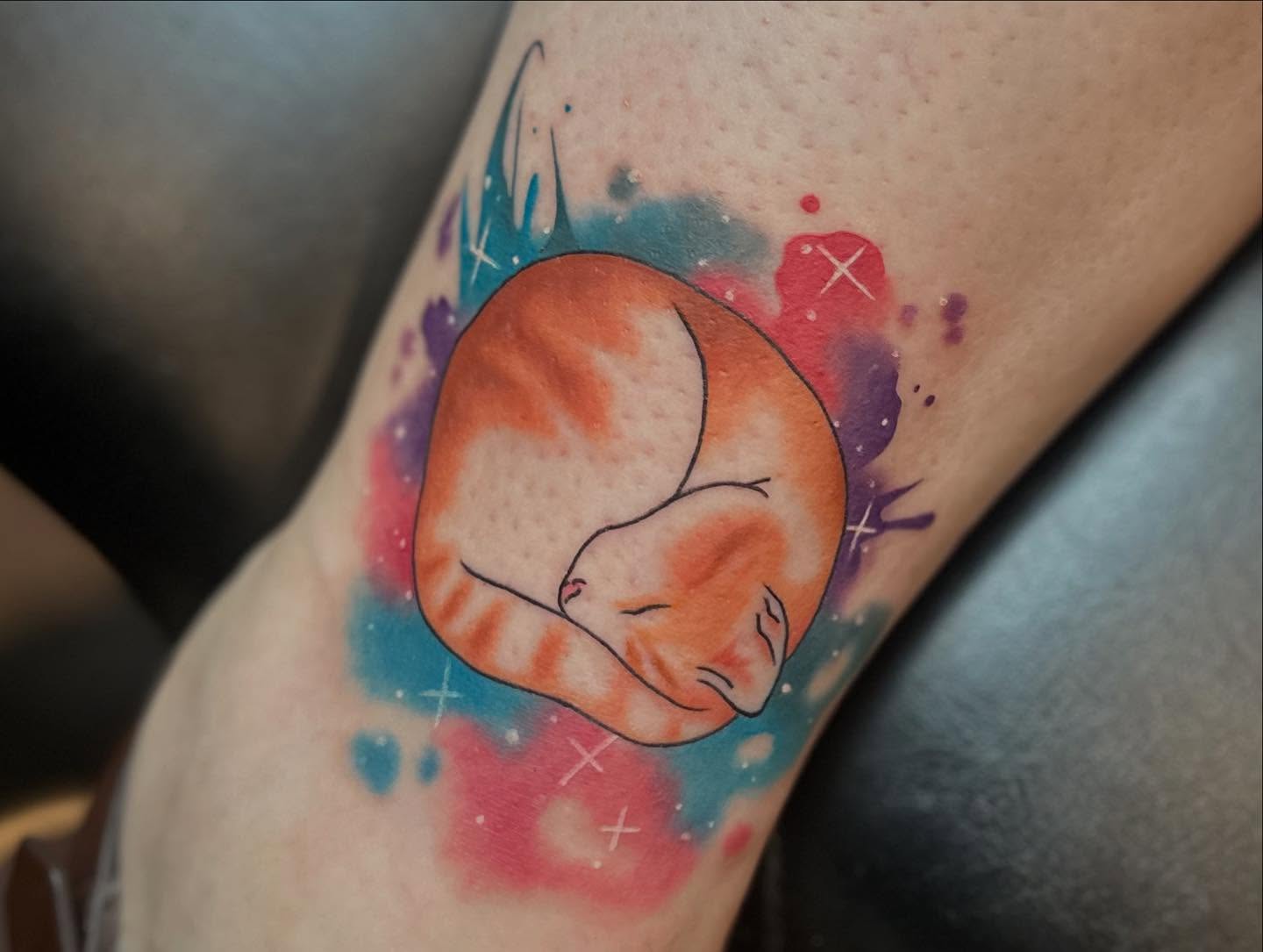 Sleeping cat watercolor tattoo on the forearm by Megan Sierra