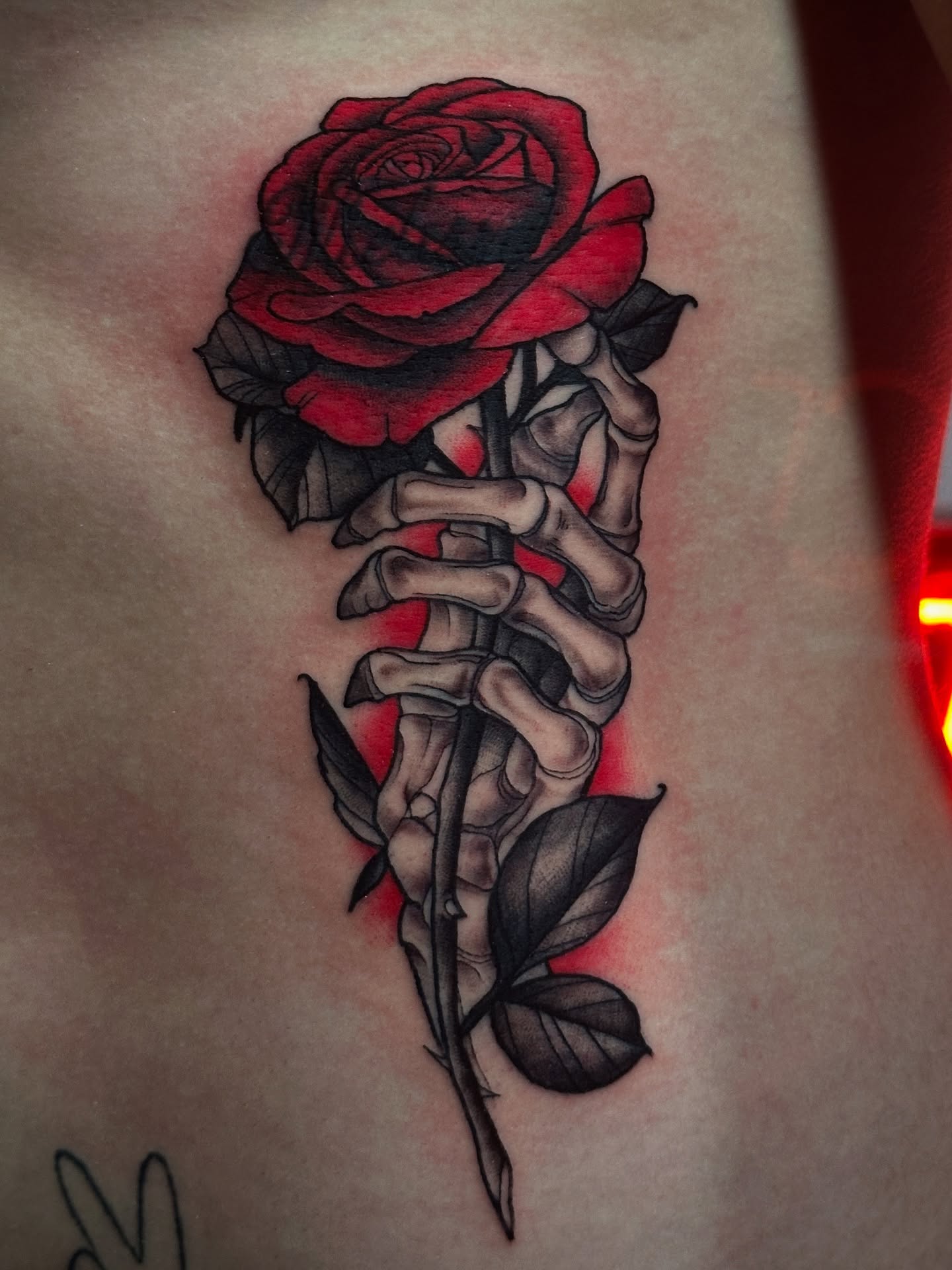 Red rose with skeleton hand realism tattoo by Dennis Alejandro