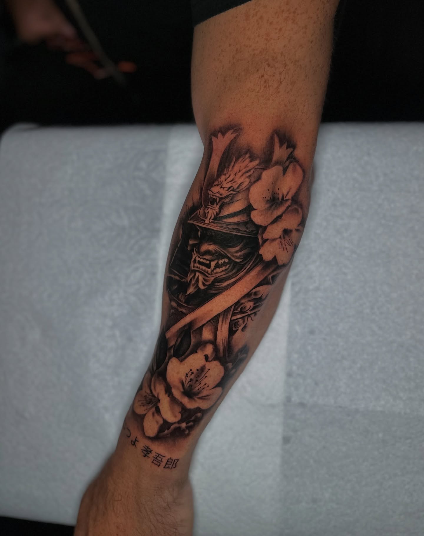 Samurai warrior and flowers realism tattoo on the forearm by Mando
