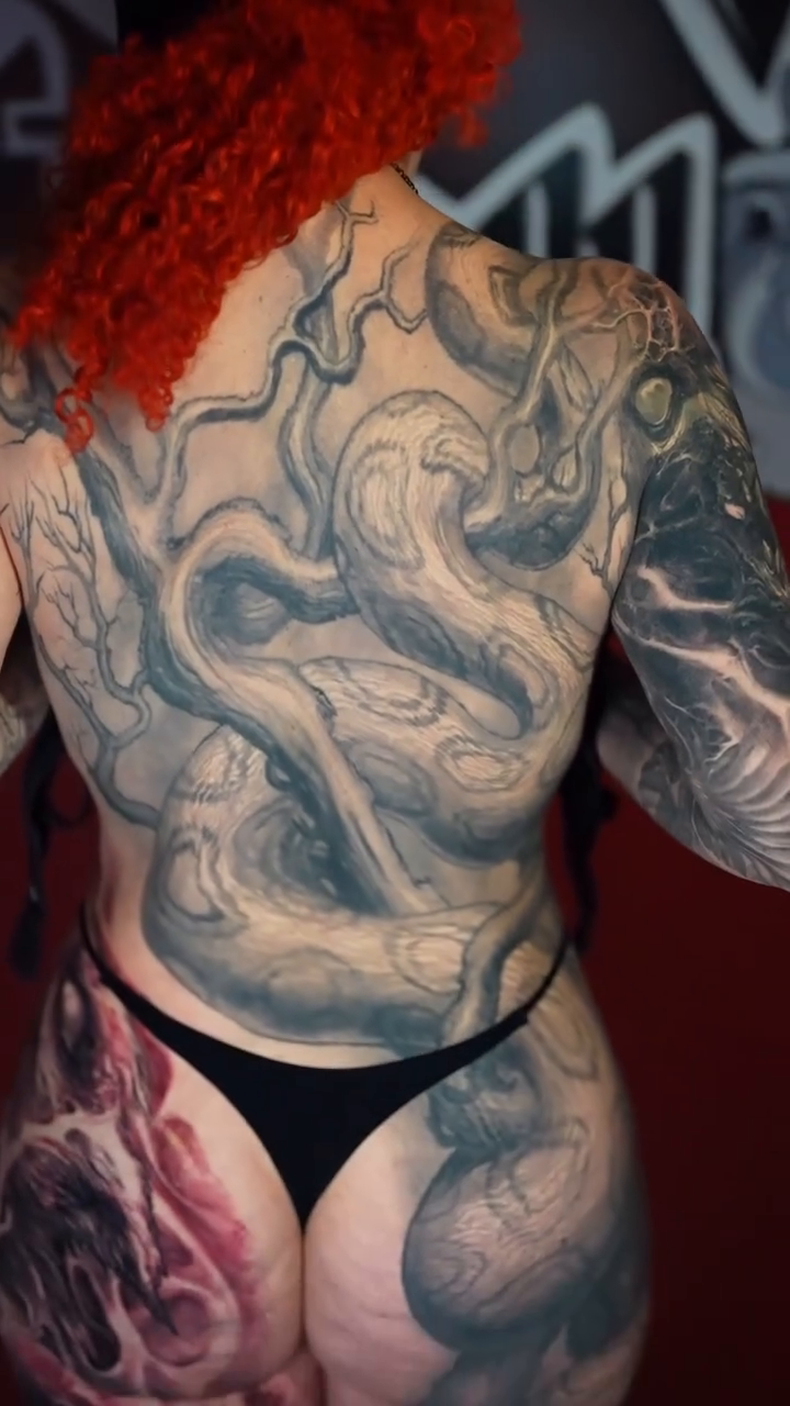 Serpent and floral motifs realism tattoo by Paul Booth