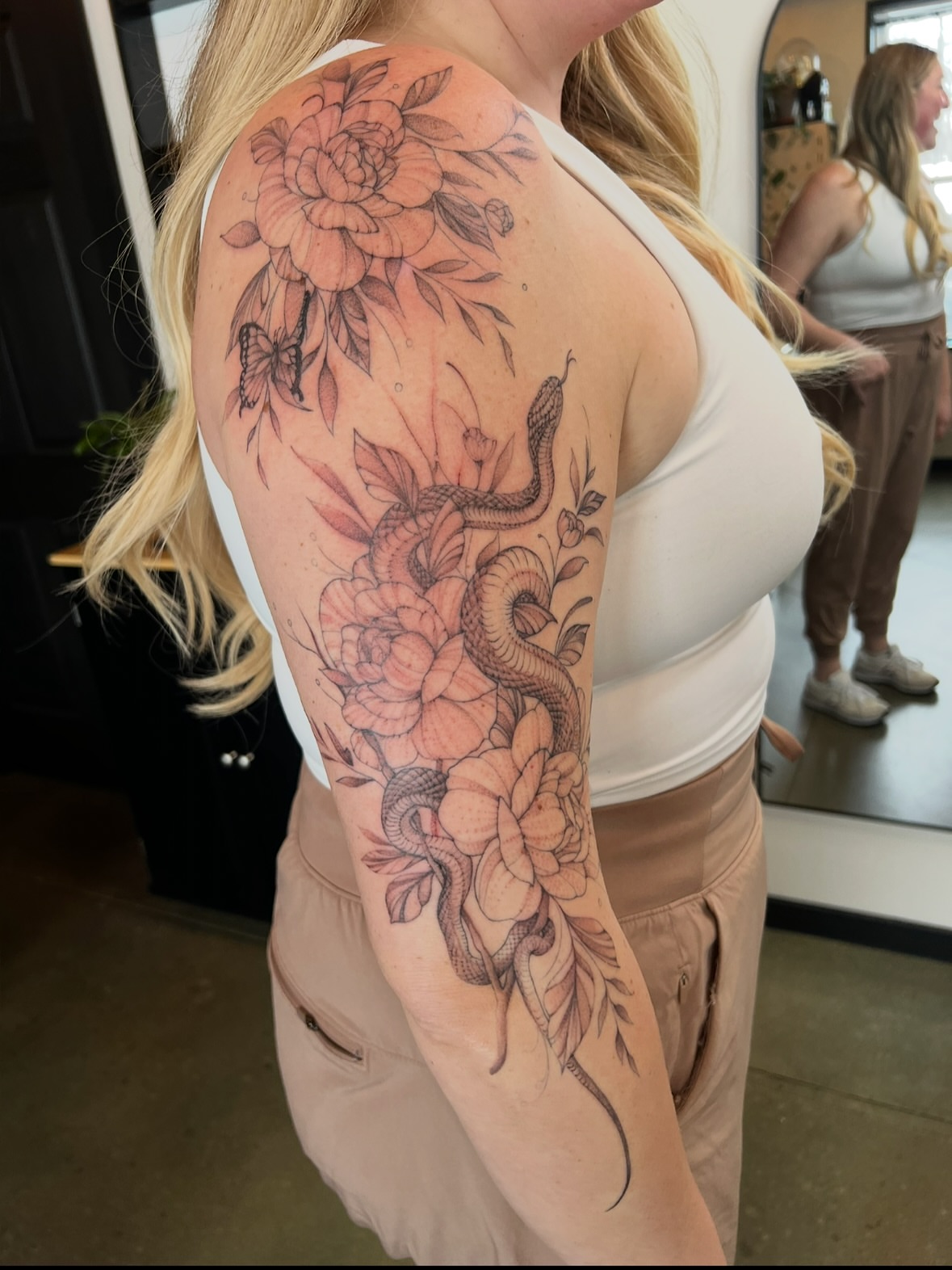 Snake and peony realism tattoo on the upper arm by Amanda Leitch