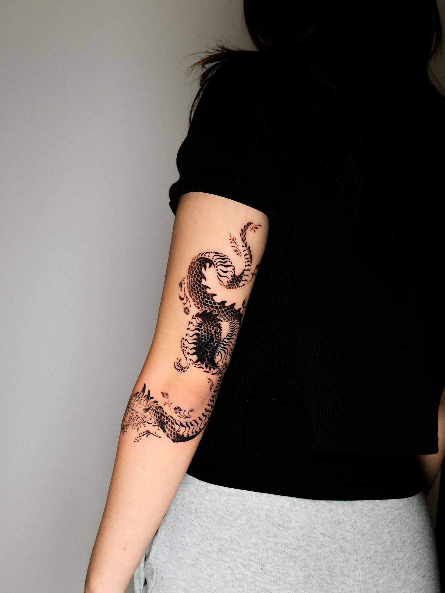Dragon black and grey tattoo on the forearm by Grace Zarmina Hessam