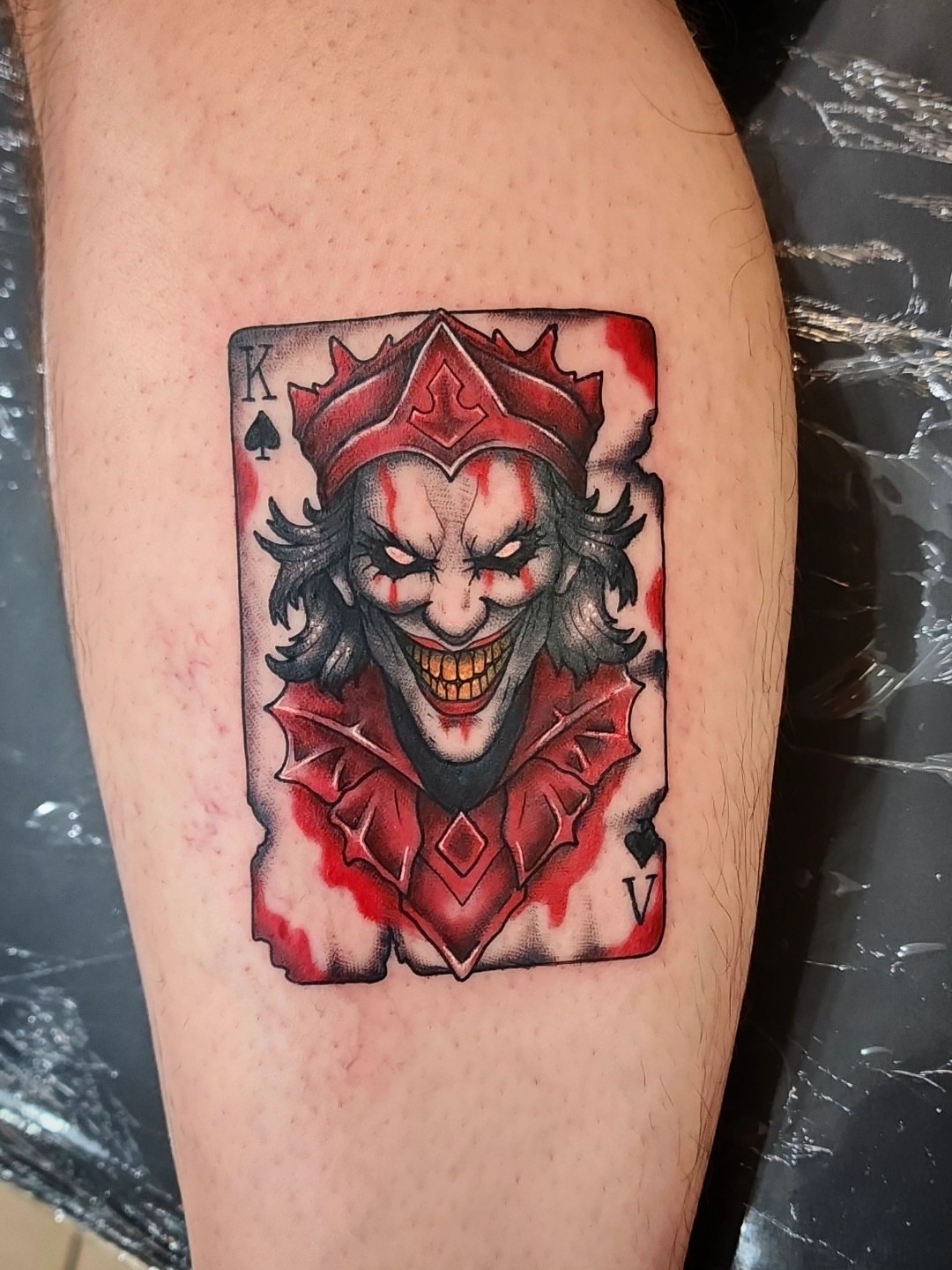 Joker playing card dark realism tattoo on the thigh by bobby allensworth