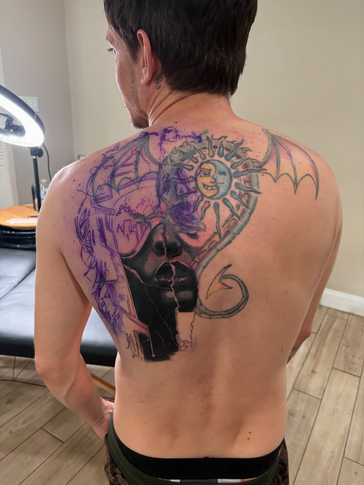 Skull with sun and bat wings American traditional tattoo on the back by Lemaih Gonzalez