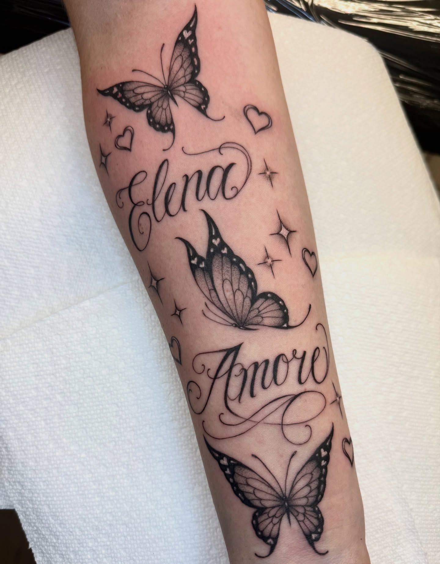 Butterflies and names black and grey tattoo on the forearm by dinah