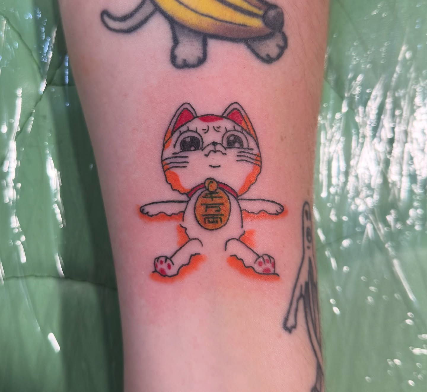 Maneki-neko new school tattoo on the forearm by Minxxy Tattoos