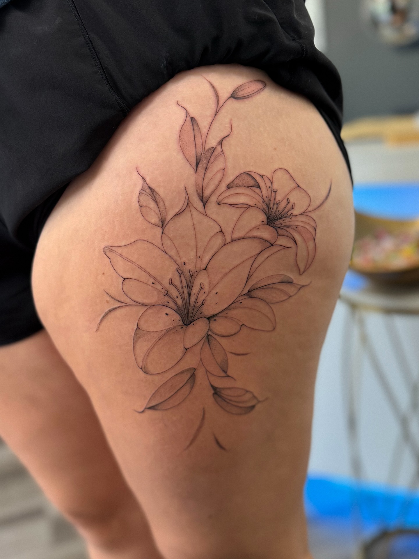 Lilies black and grey tattoo on the thigh by Daniel Montoya, Charlotte, North Carolina