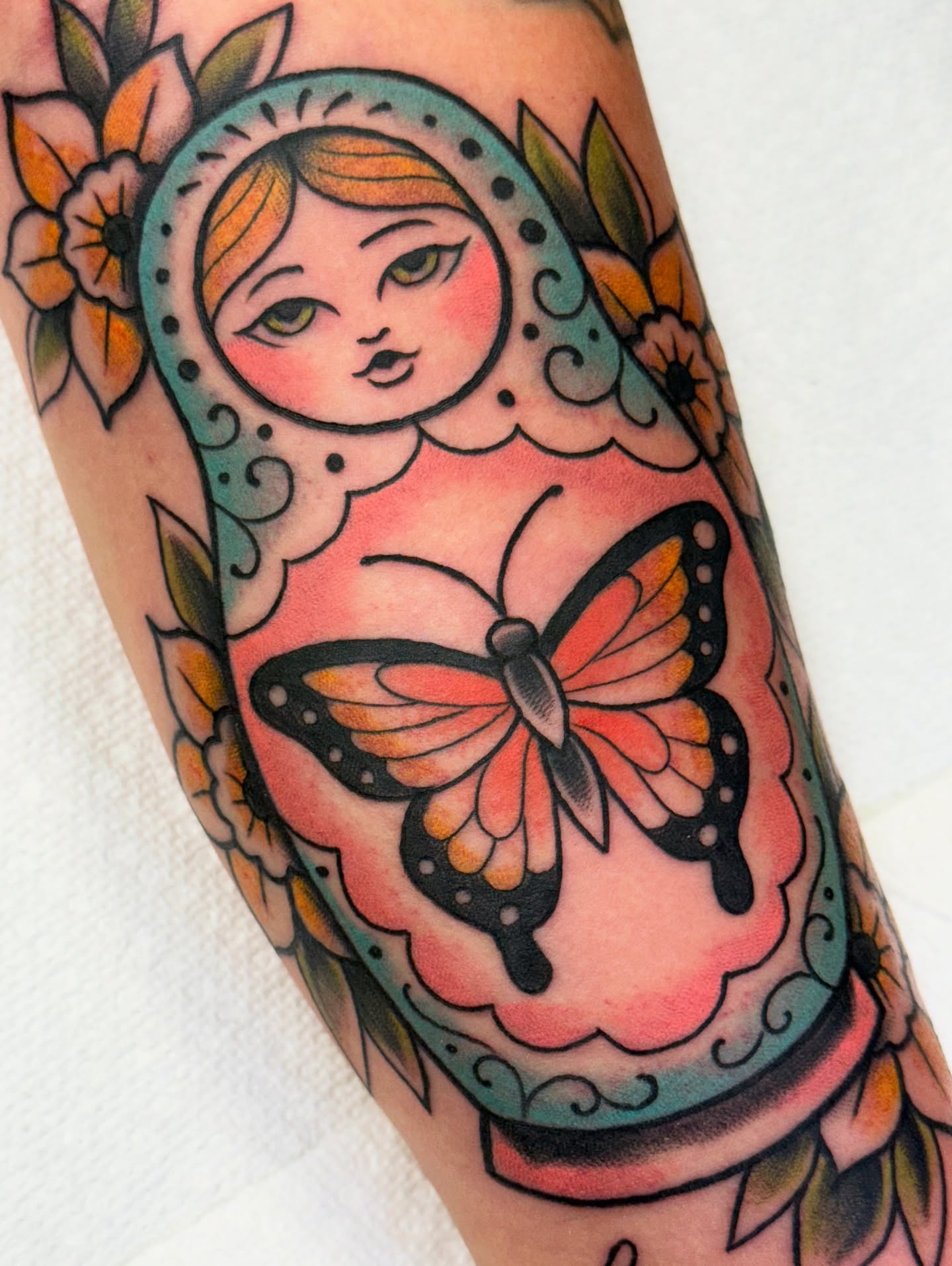 Matryoshka doll with butterfly American traditional tattoo on the forearm by jenna clark🎨