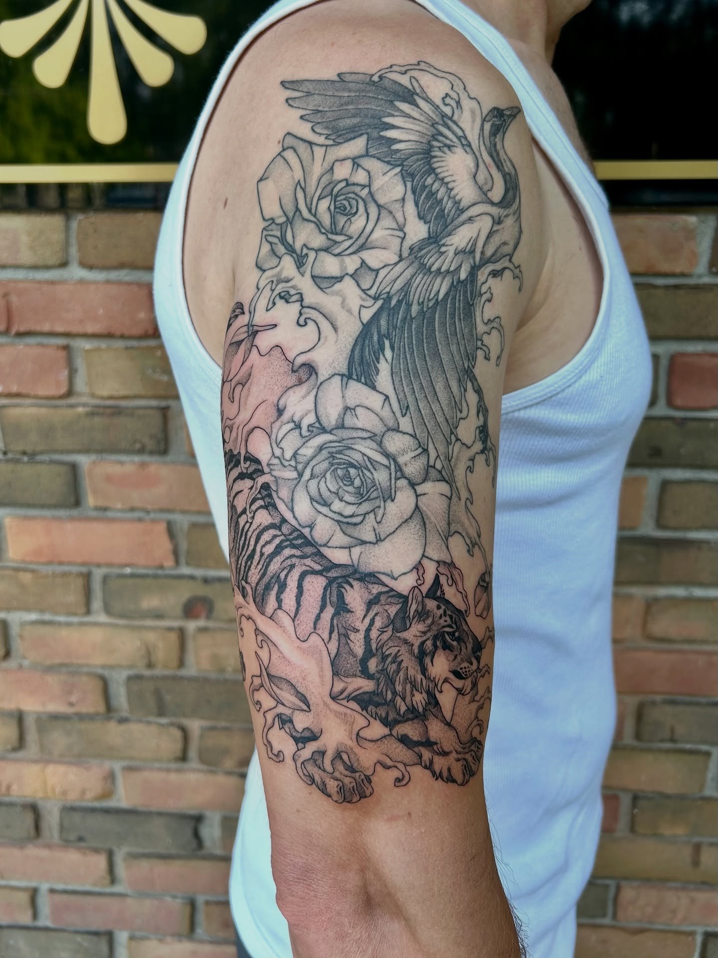 Tiger and roses realism tattoo on the forearm by Taylor Heidtbrink