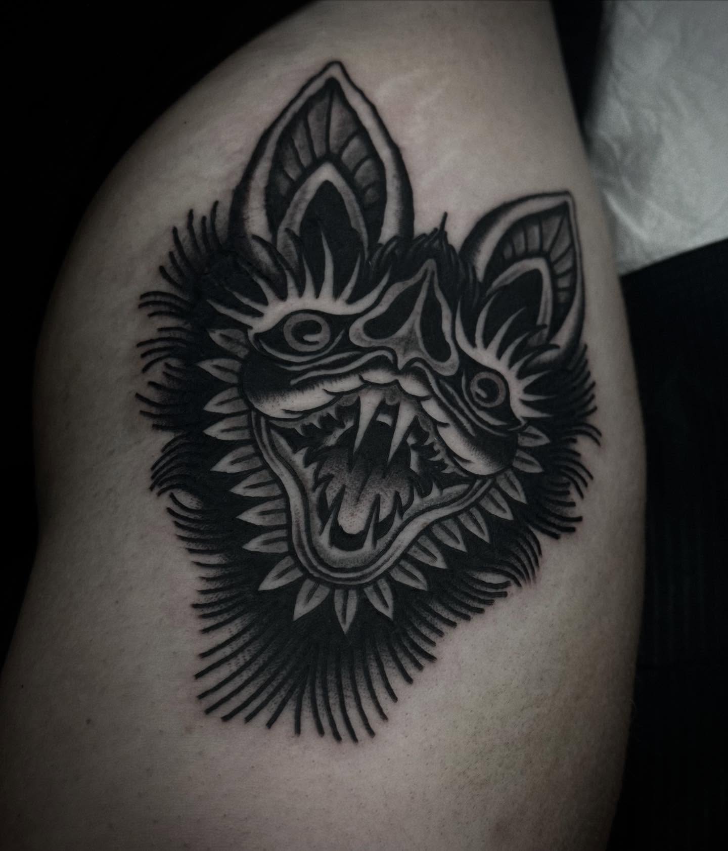 Demon head black and grey tattoo on the thigh by Ally noel