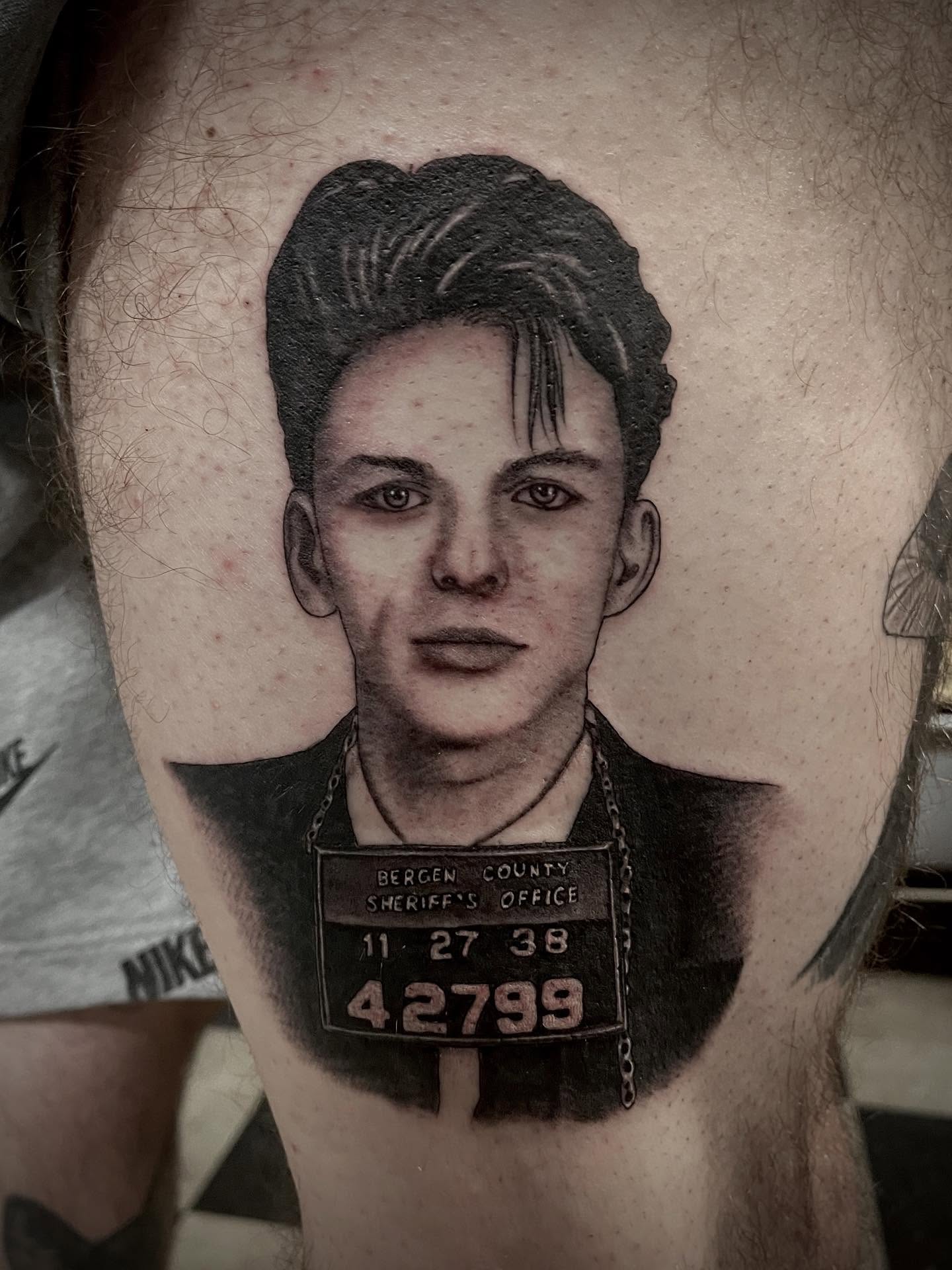 Mugshot portrait realism tattoo on the thigh by Jacob Finelli