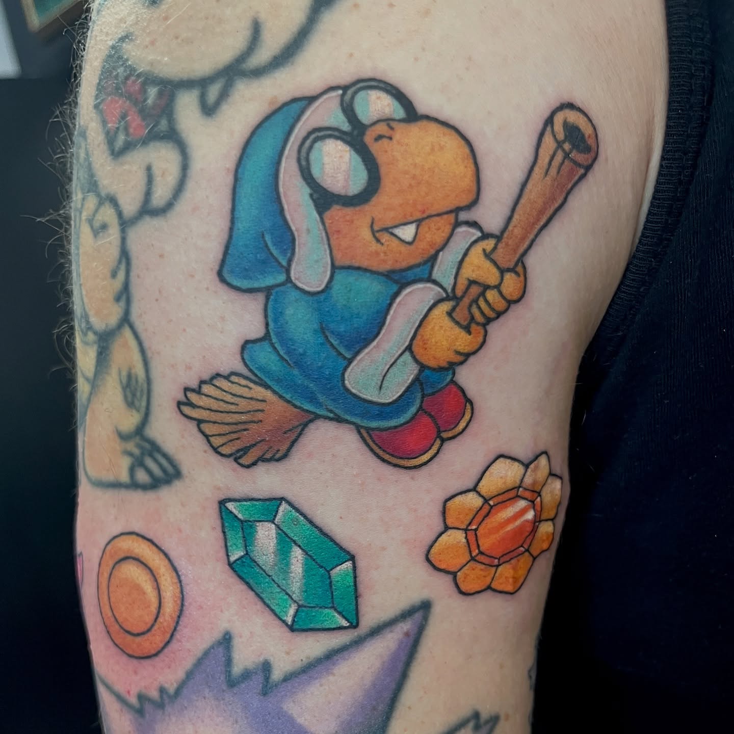Dinosaur with bat new school tattoo on the forearm by Cheyanne Peck