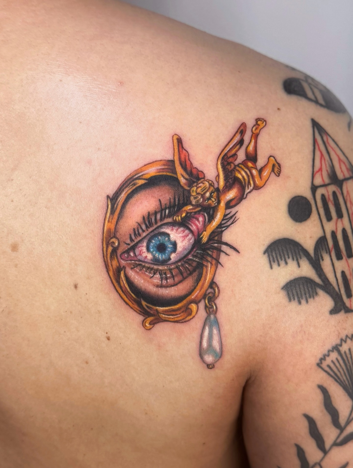 Eye with cherub neo-traditional tattoo on the shoulder by Franky A Bonifacio, Seattle, Washington
