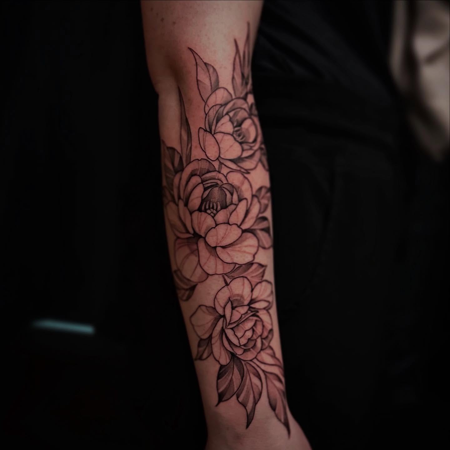 Flowers black and grey tattoo on the forearm by Sebastian Livingston