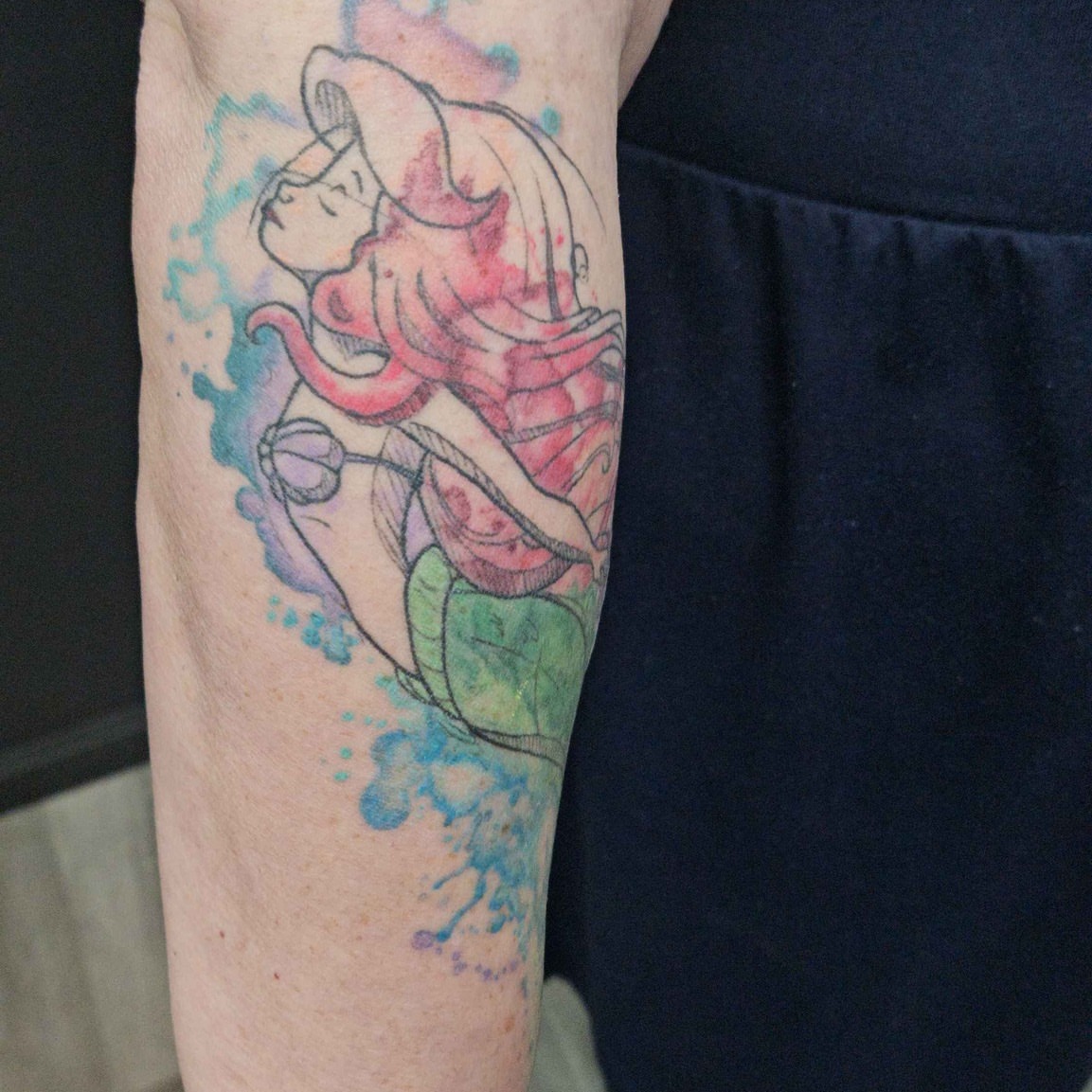 Mermaid watercolor tattoo on the forearm by Iram Withencroft