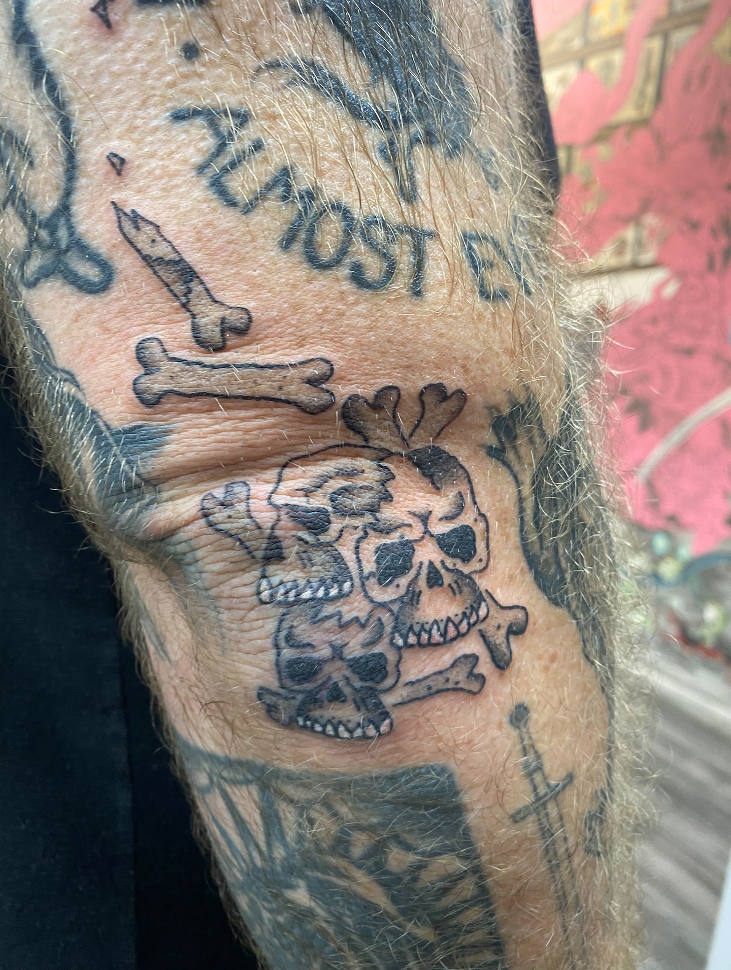 Skulls and bones black and grey tattoo on the forearm by Mike Tapia