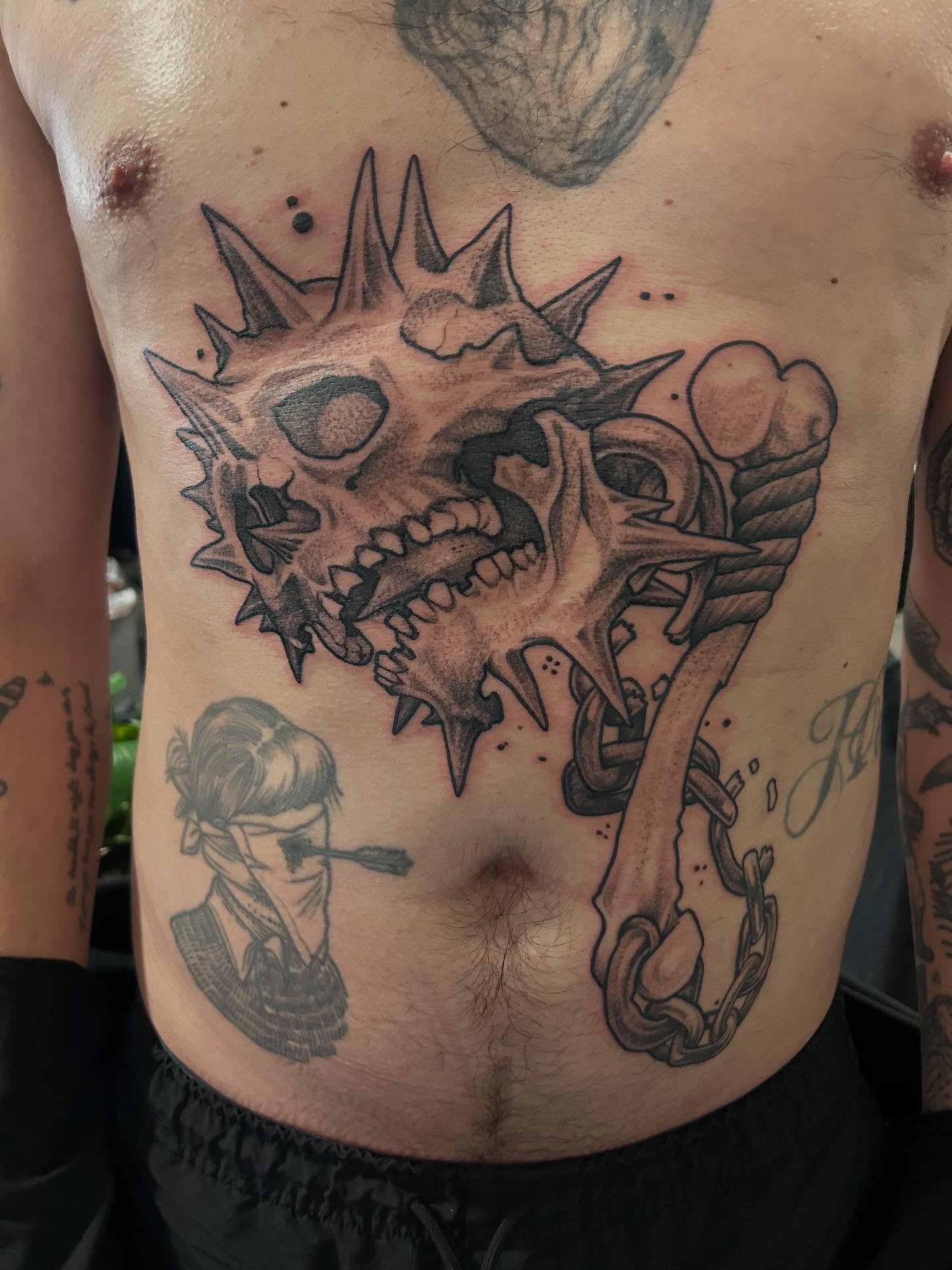Skull with spikes black and grey tattoo on the chest by Josh Williams, Chattanooga, Tennessee