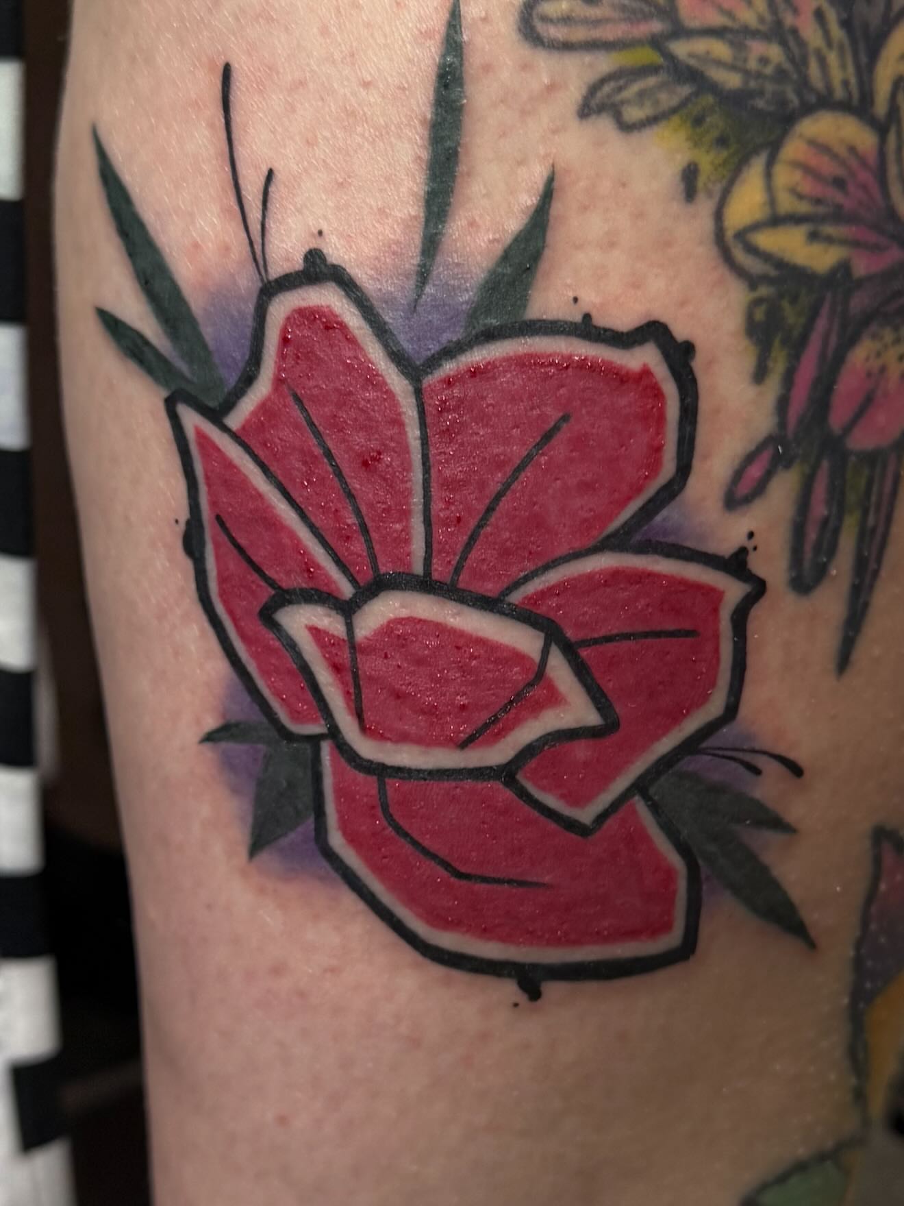 Red flower American traditional tattoo on the forearm by Romans