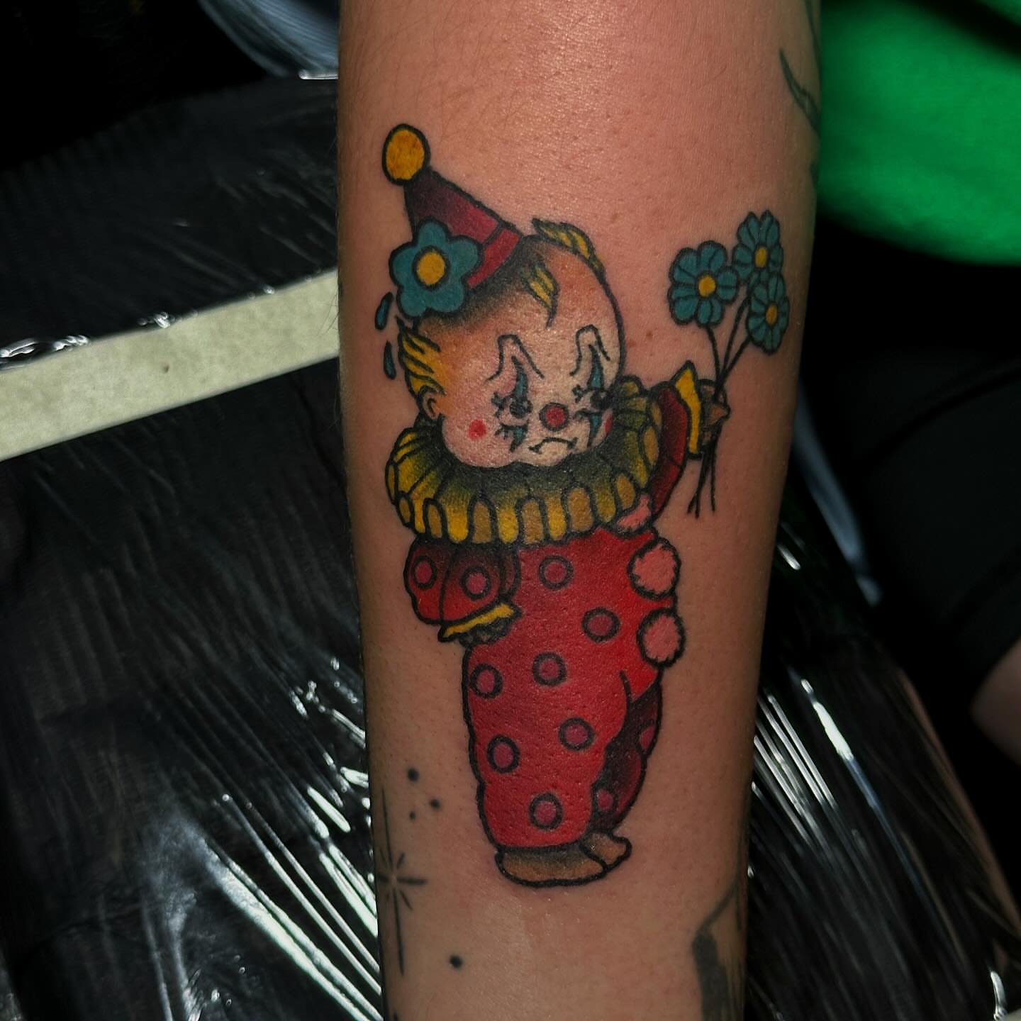 Sad clown American traditional tattoo on the forearm by Elizabeth Tabler