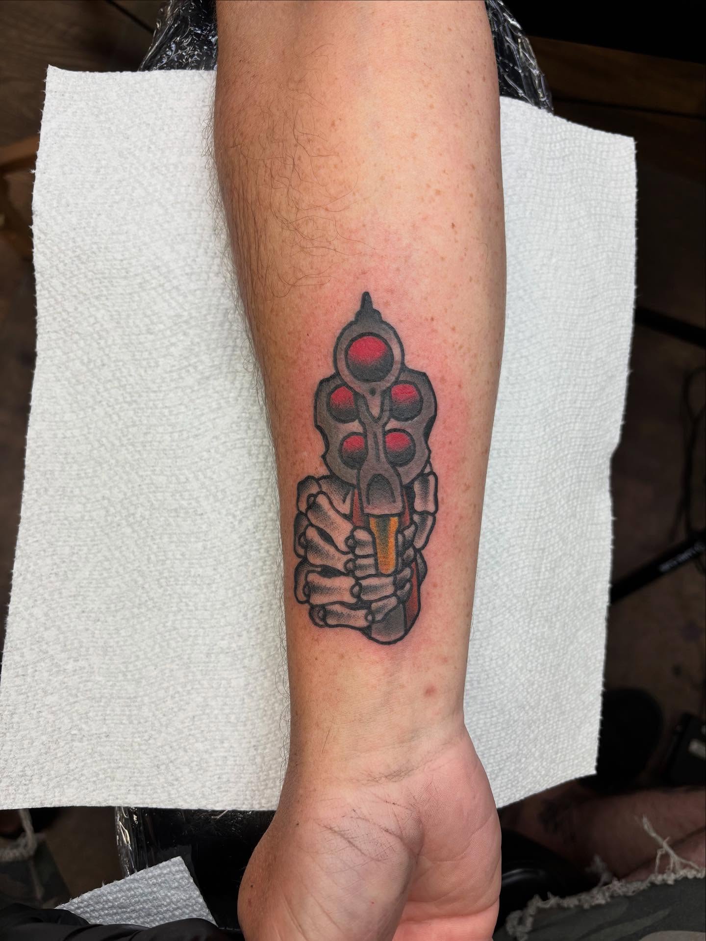 Gun American traditional tattoo on the forearm by Dave