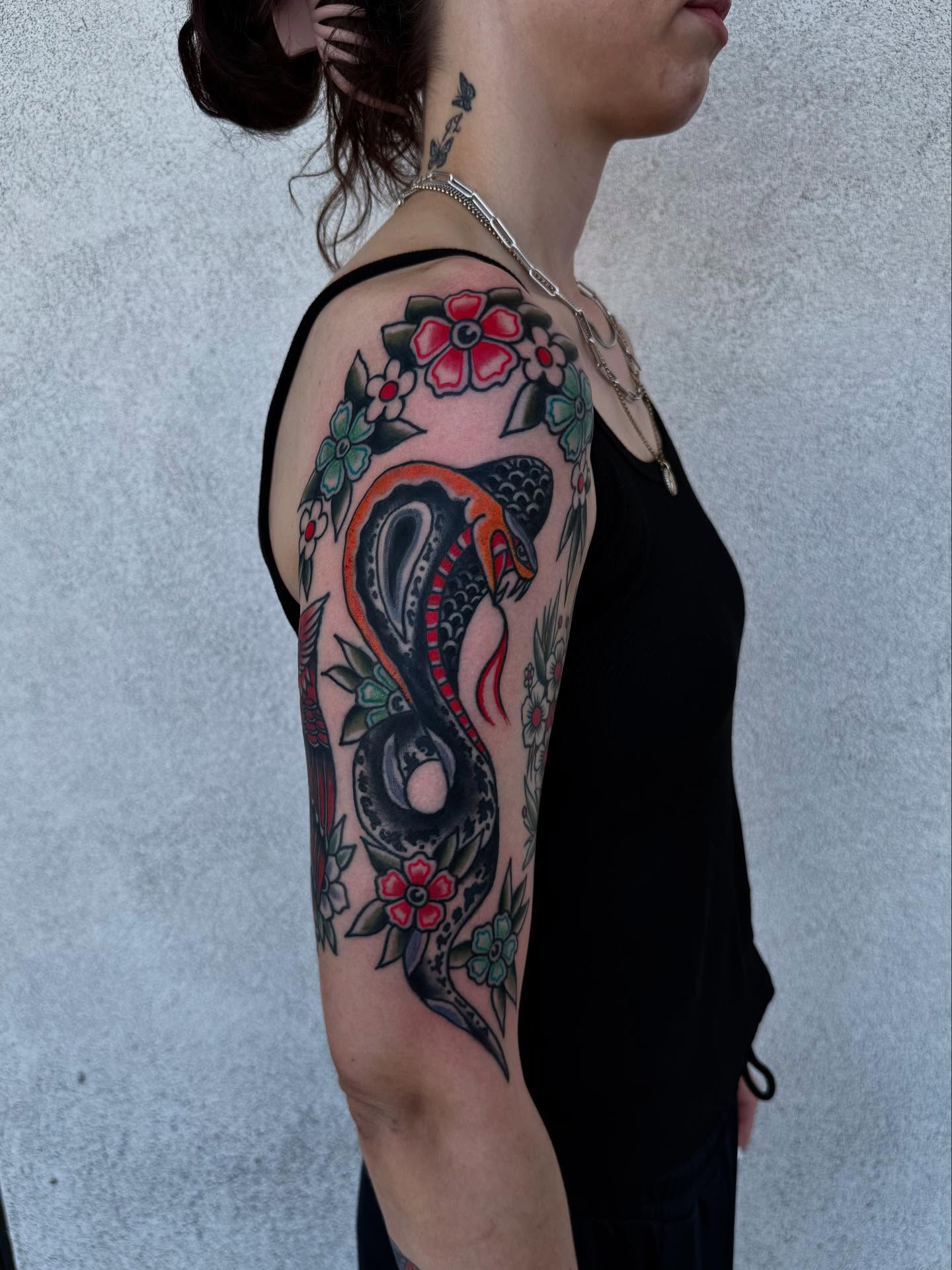 Snake and flowers American traditional tattoo on the upper arm by Noah Diffenderfer, Phoenix, Arizona