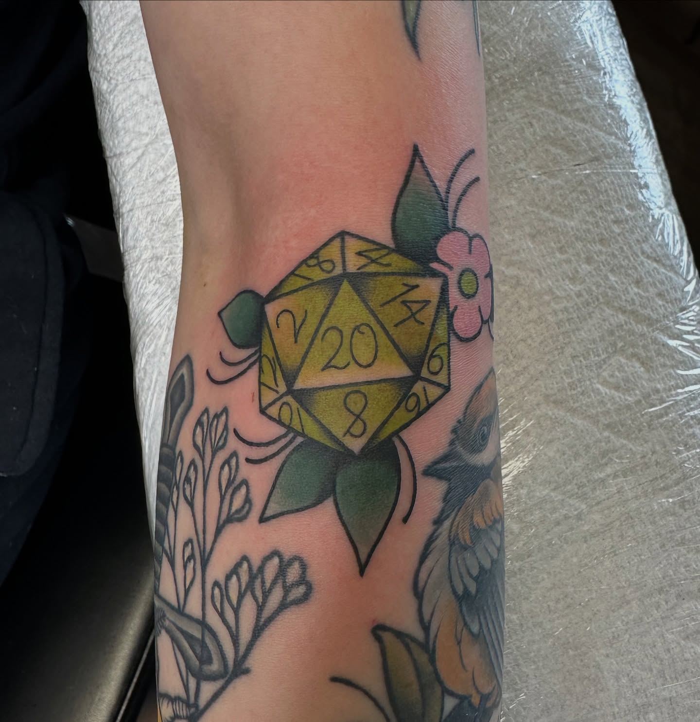 Yellow d20 American traditional tattoo on the forearm by Lauren Howard Tattoos