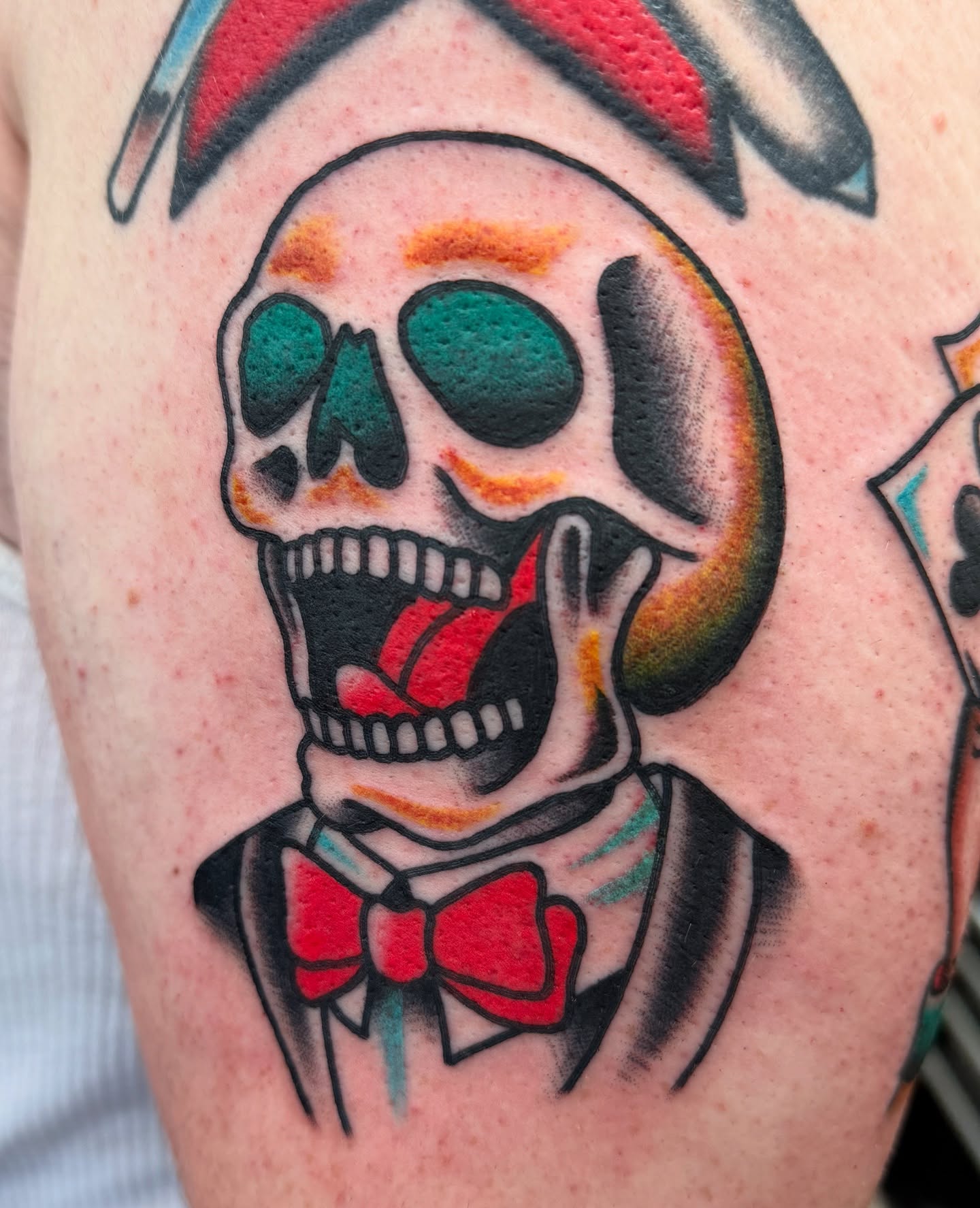 Skull in suit American traditional tattoo on the upper arm by Joey Burdette Tattoos