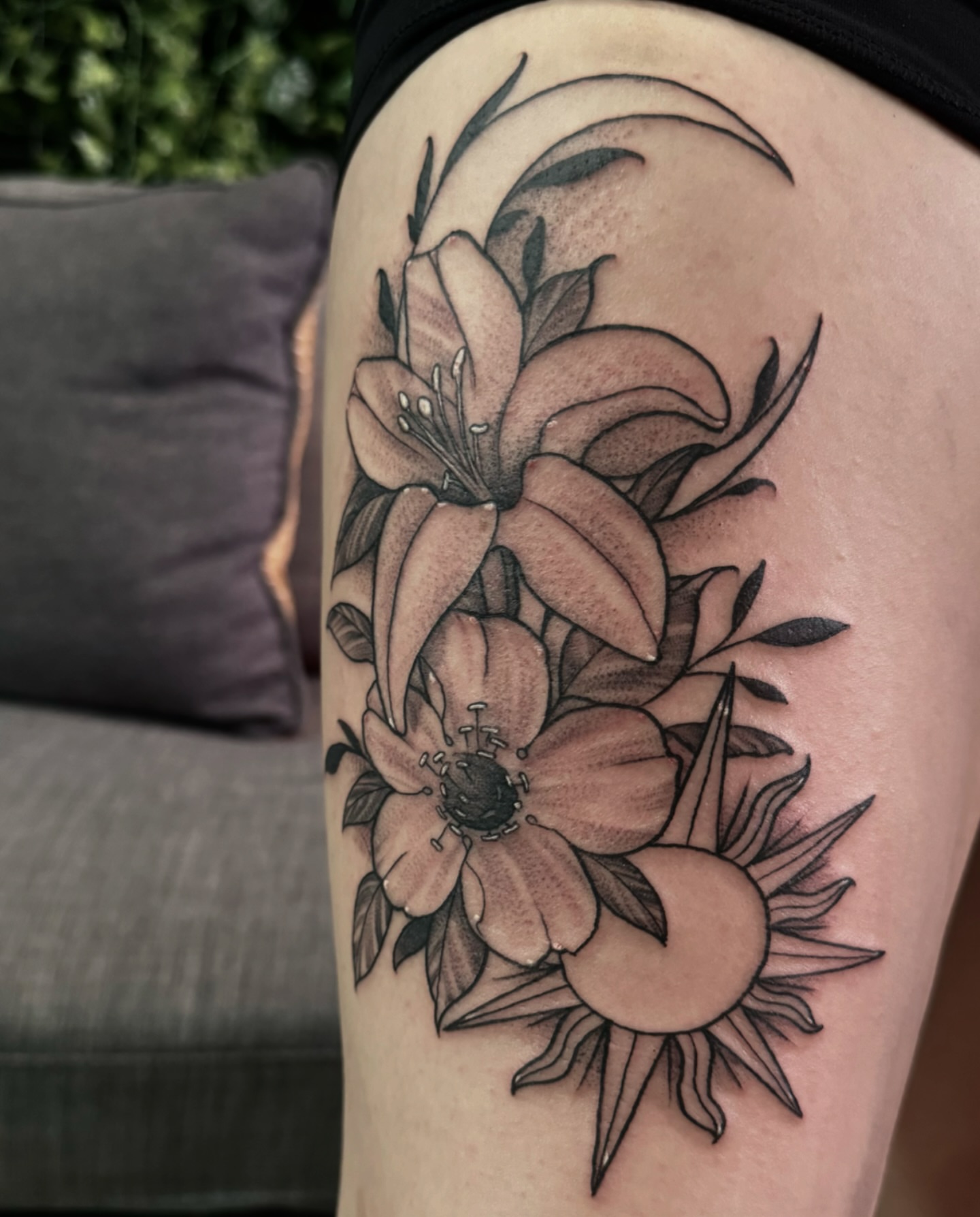 Lilies and sun realism tattoo on the thigh by Joseph Marshall