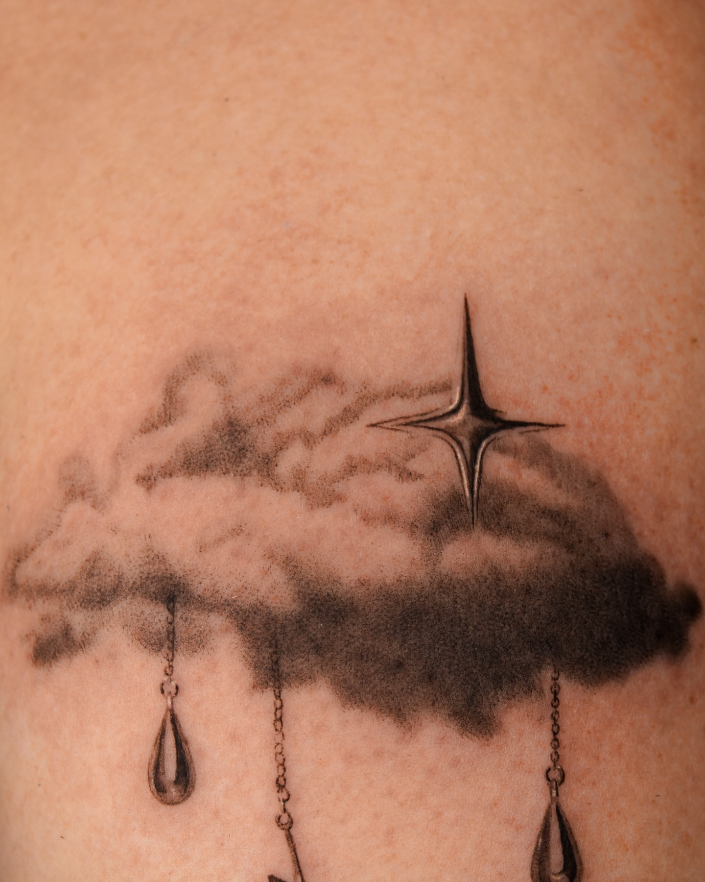 Cloud with star and raindrops black and grey tattoo on the back by ππ²π§π§ ππ’π₯πππ« (π©π¦