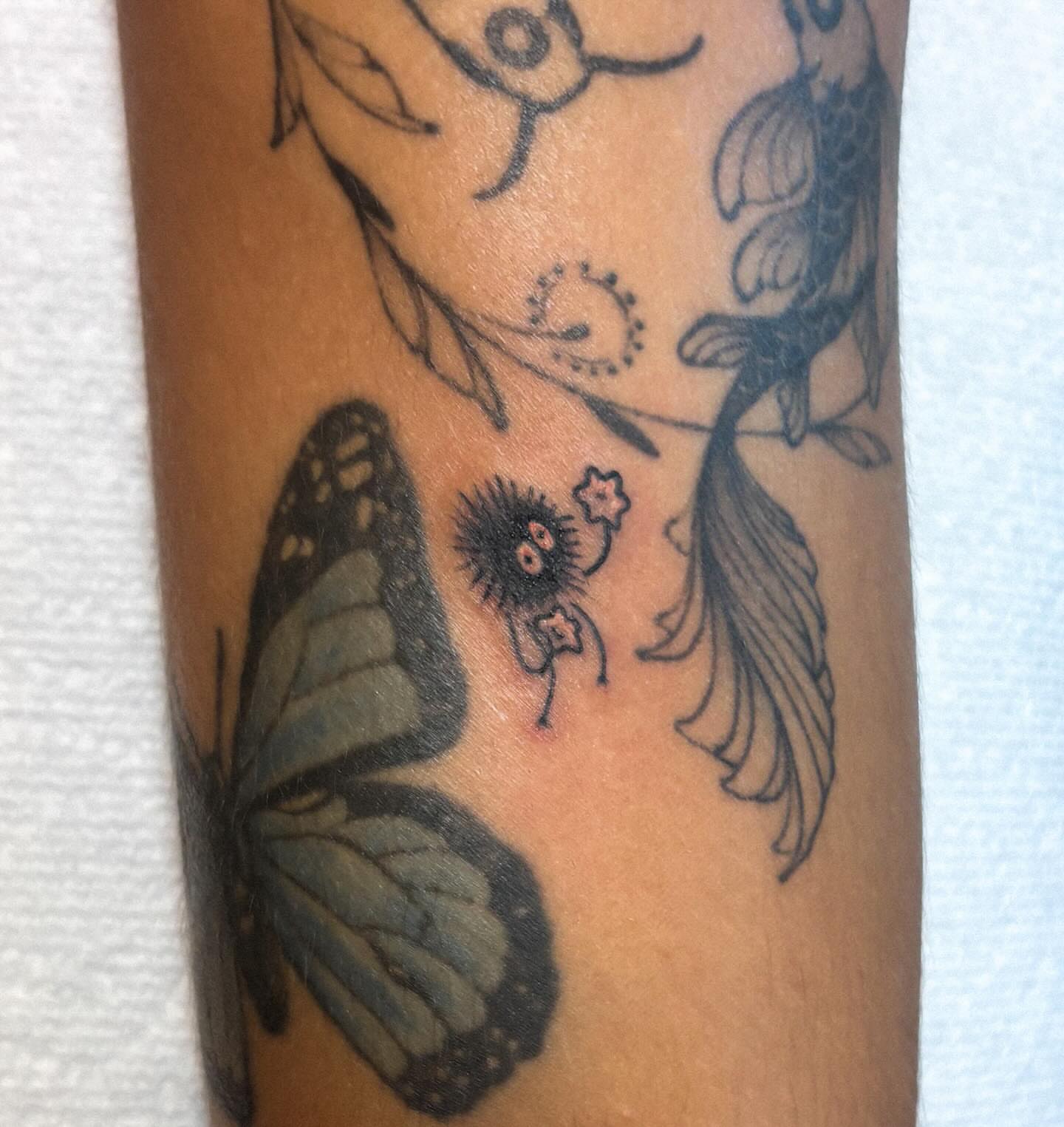 Butterfly and flower black and grey tattoo on the forearm by Katelyn Spence