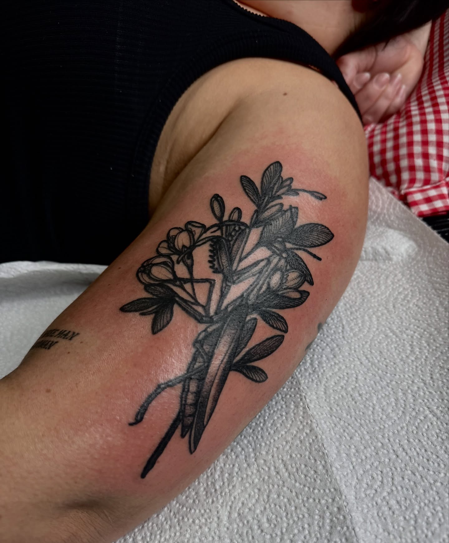 Praying mantis and flowers black and grey tattoo on the forearm by Saffron Florea, Tiffin, Ohio