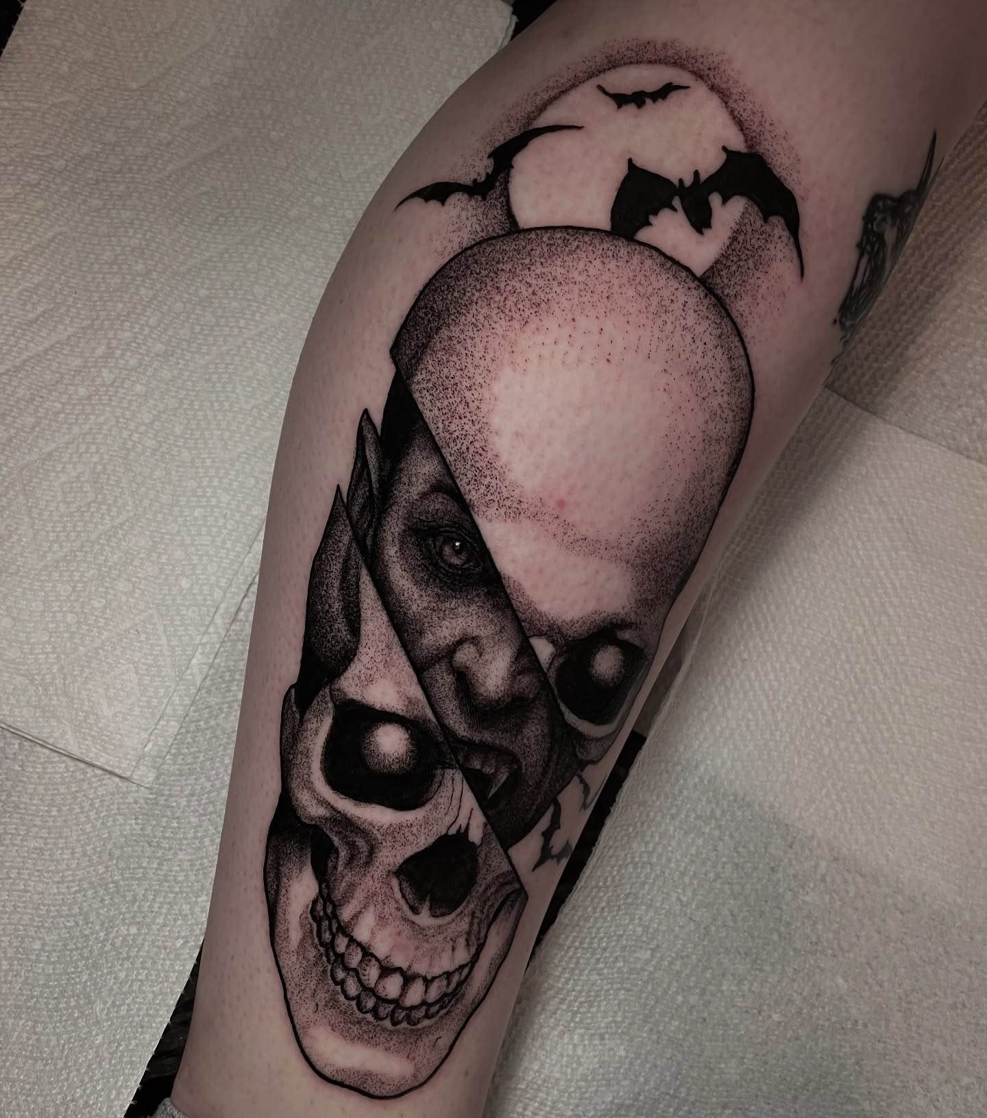 Skull and face dotwork tattoo on the forearm by Ian Spong