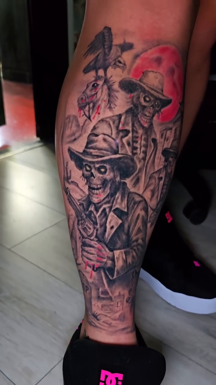 Skeleton figures under a red moon dark realism tattoo by Jesse James, Las Vegas, Nevada