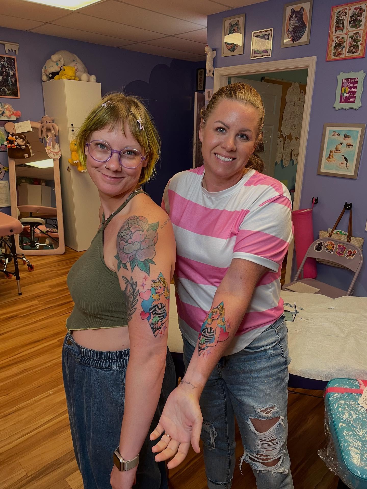 Floral and cartoon characters American traditional tattoo on the upper arm by Sarah Baldwin