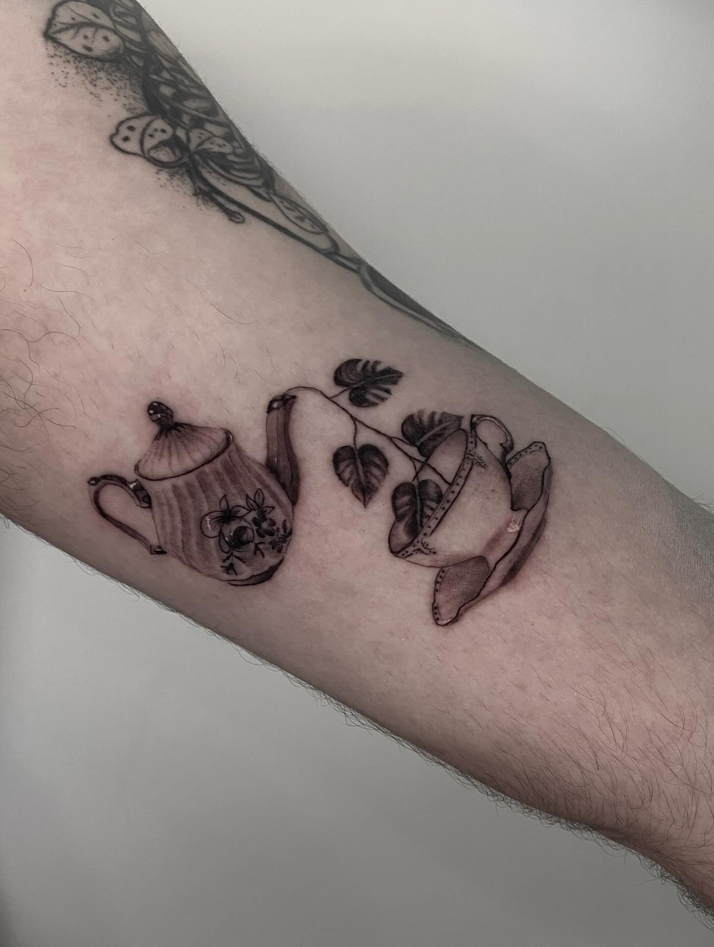 Teapot and cup black and grey tattoo on the forearm by Stephanie Pedraza