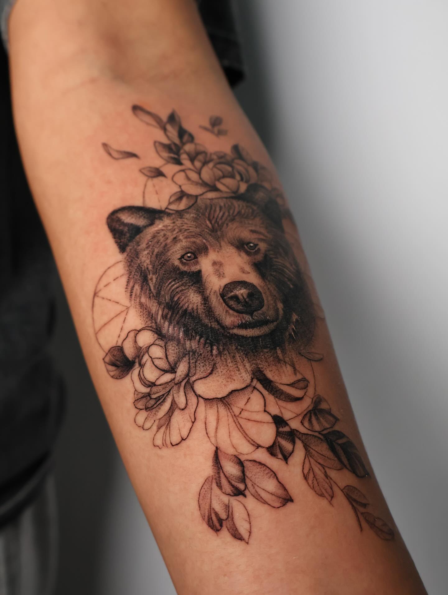 Bear with floral crown dotwork tattoo on the forearm by Stephanie Pedraza