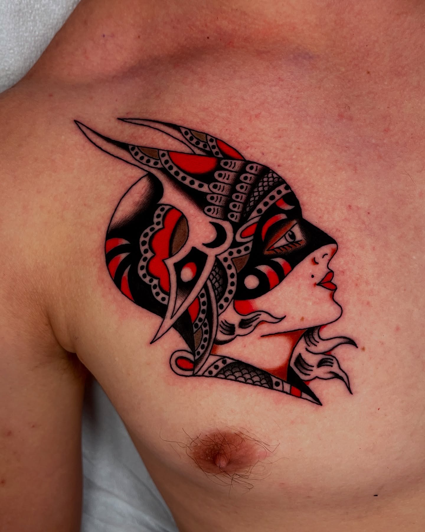 Woman's face American traditional tattoo on the chest by Chase Tucker