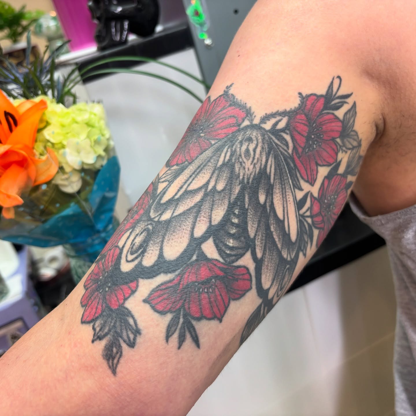 Butterfly and flowers black and grey tattoo on the forearm by Ivanna