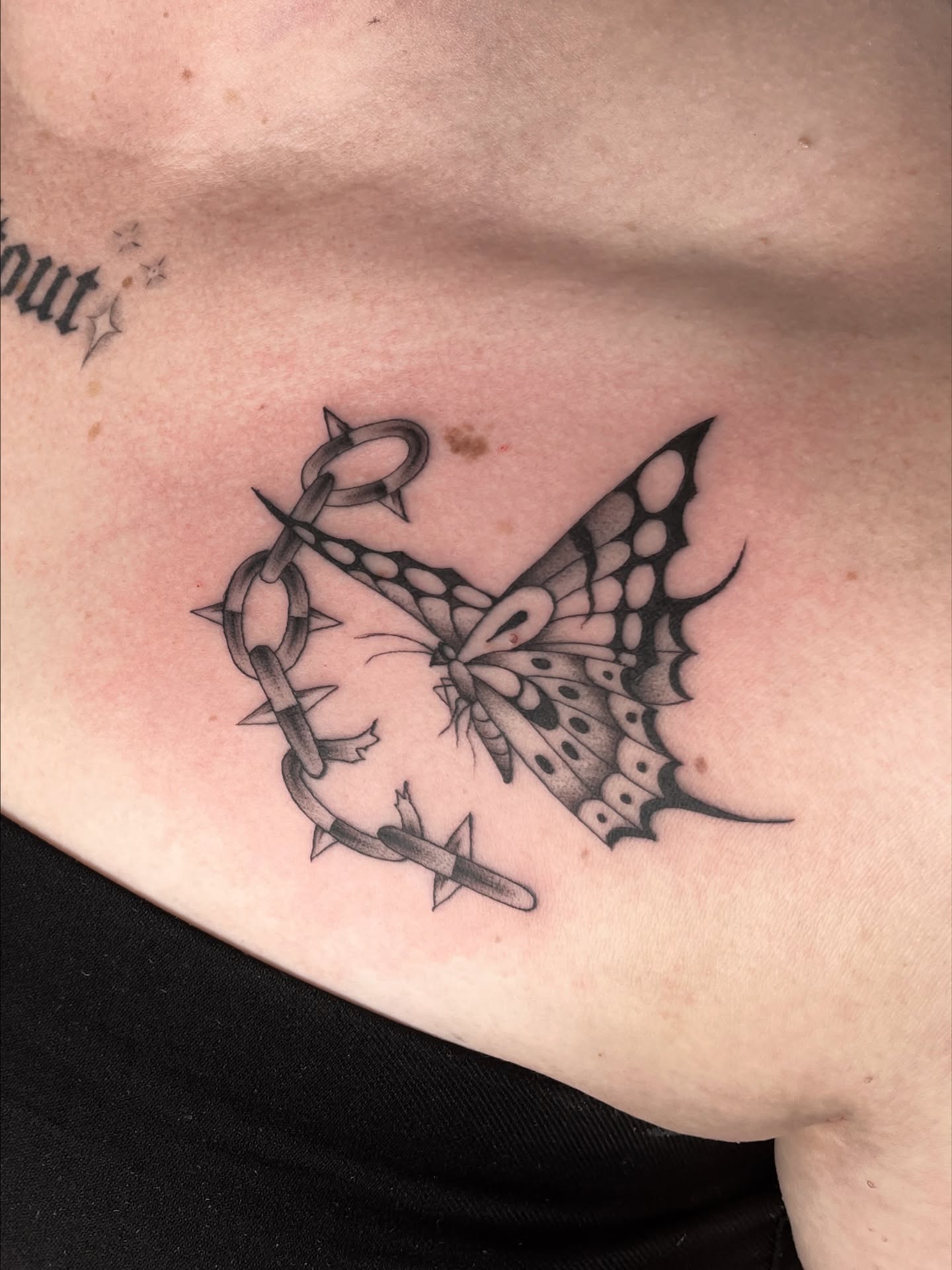 Butterfly and chain black and grey tattoo on the ribs by Dakota Jenner