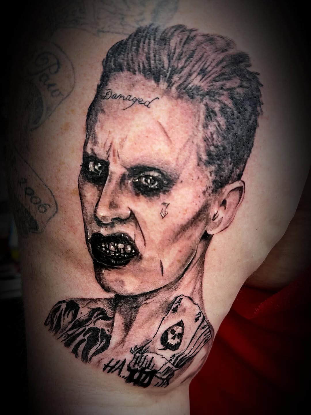 Jared Leto's Joker realism tattoo on the shoulder by Skunk Punk