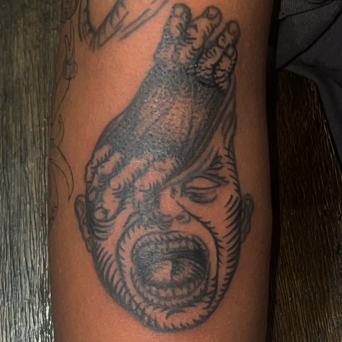 Angry face black and grey tattoo on the forearm by zion