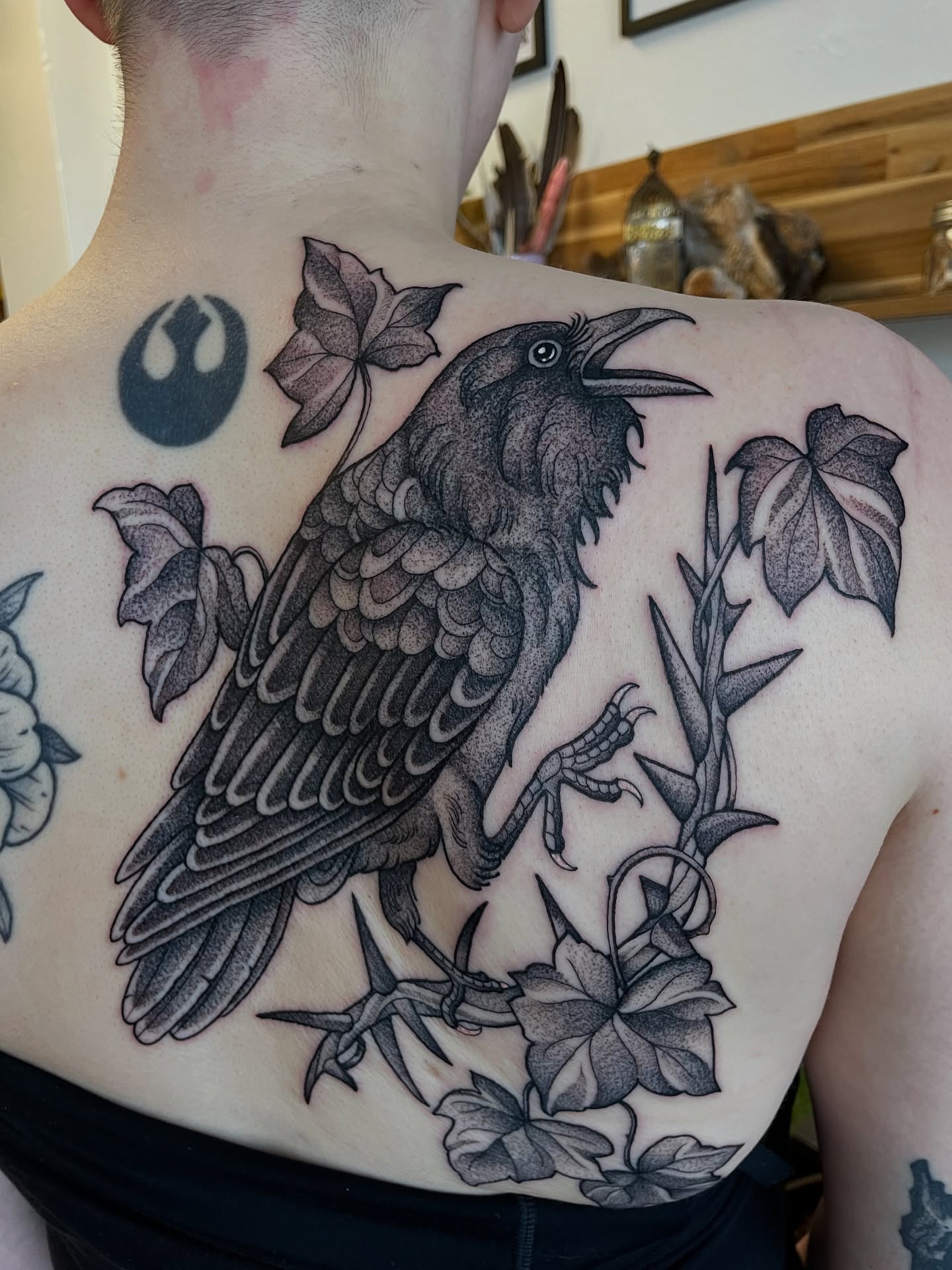 Crow and ivy realism tattoo on the back by Emily Lux