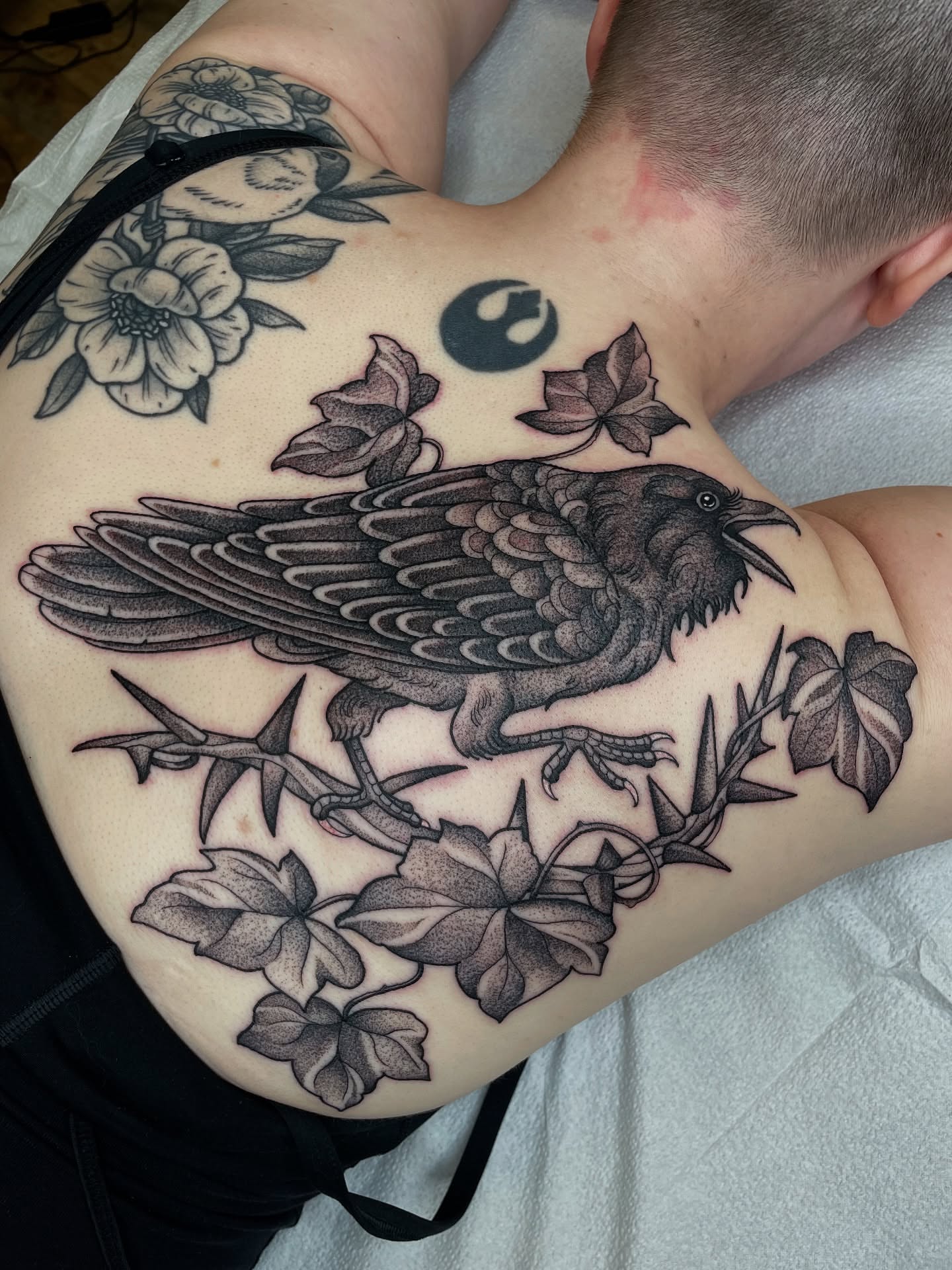 Crow and floral realism tattoo on the shoulder by Emily Lux