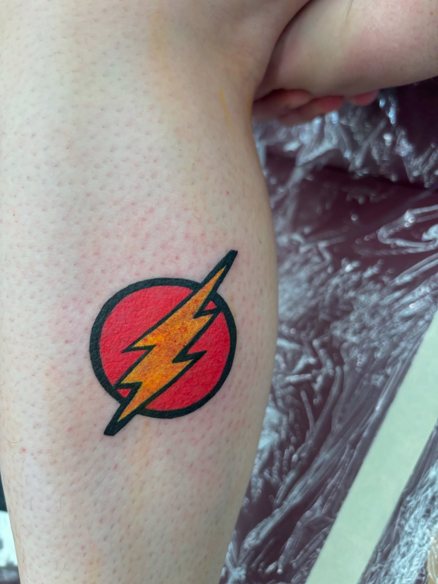 The flash logo dotwork tattoo on the forearm by Francis Cassidy