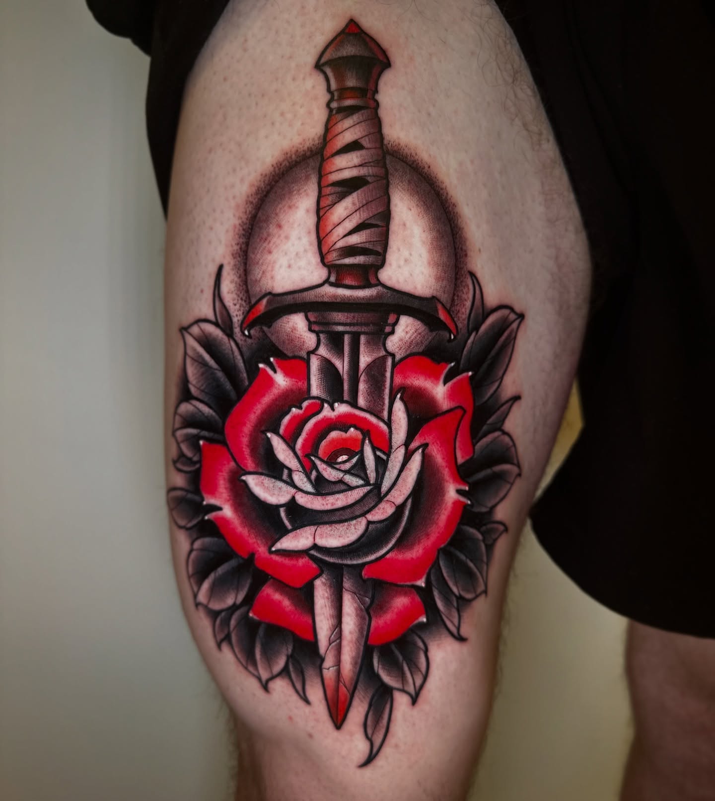 Sword through rose American traditional tattoo on the thigh by Patrick Whiting