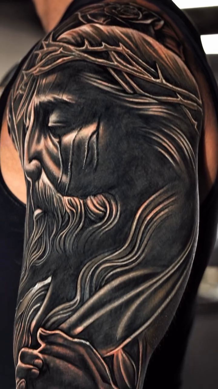 Jesus Christ and a rose realism tattoo by Jack Alvarado.