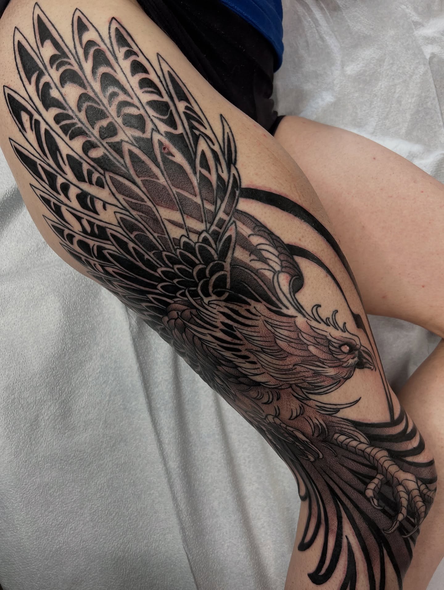 Phoenix black and grey tattoo on the thigh by Nathan Garcia