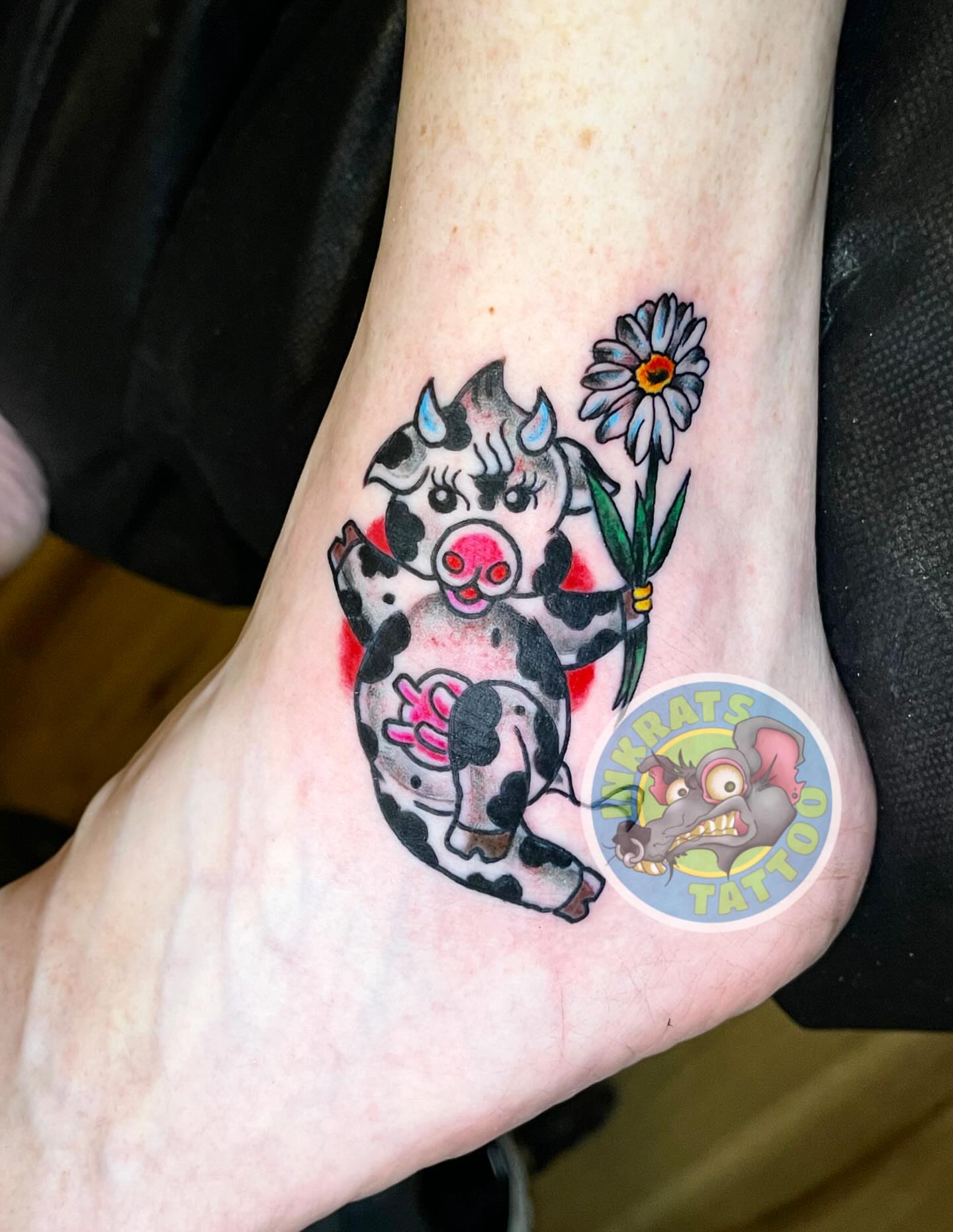 Cow with flower American traditional tattoo on the foot by Chadrick Gregory