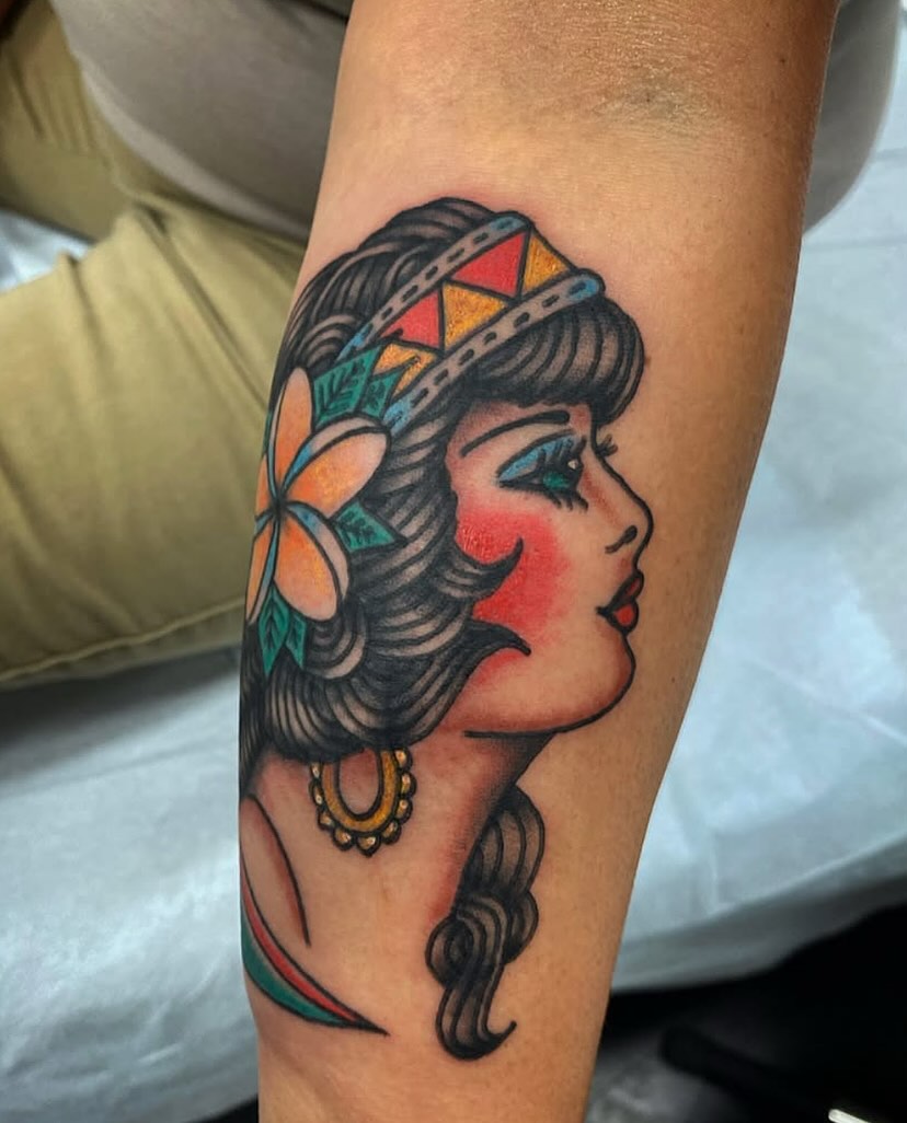 Woman with flower crown American traditional tattoo on the forearm by @rubber_band_dan, San Francisco, California