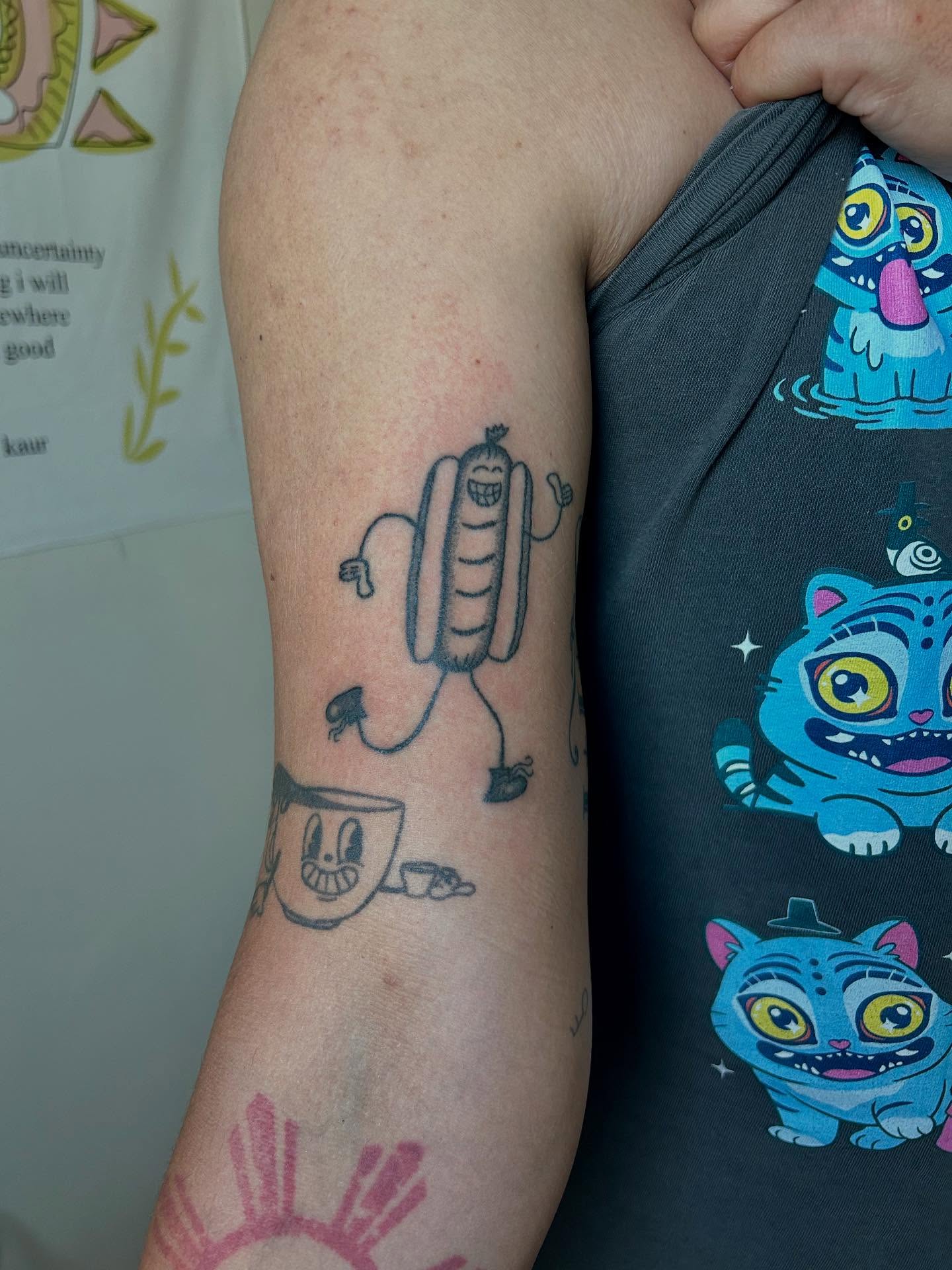 Sausage character new school tattoo on the forearm by Emma D